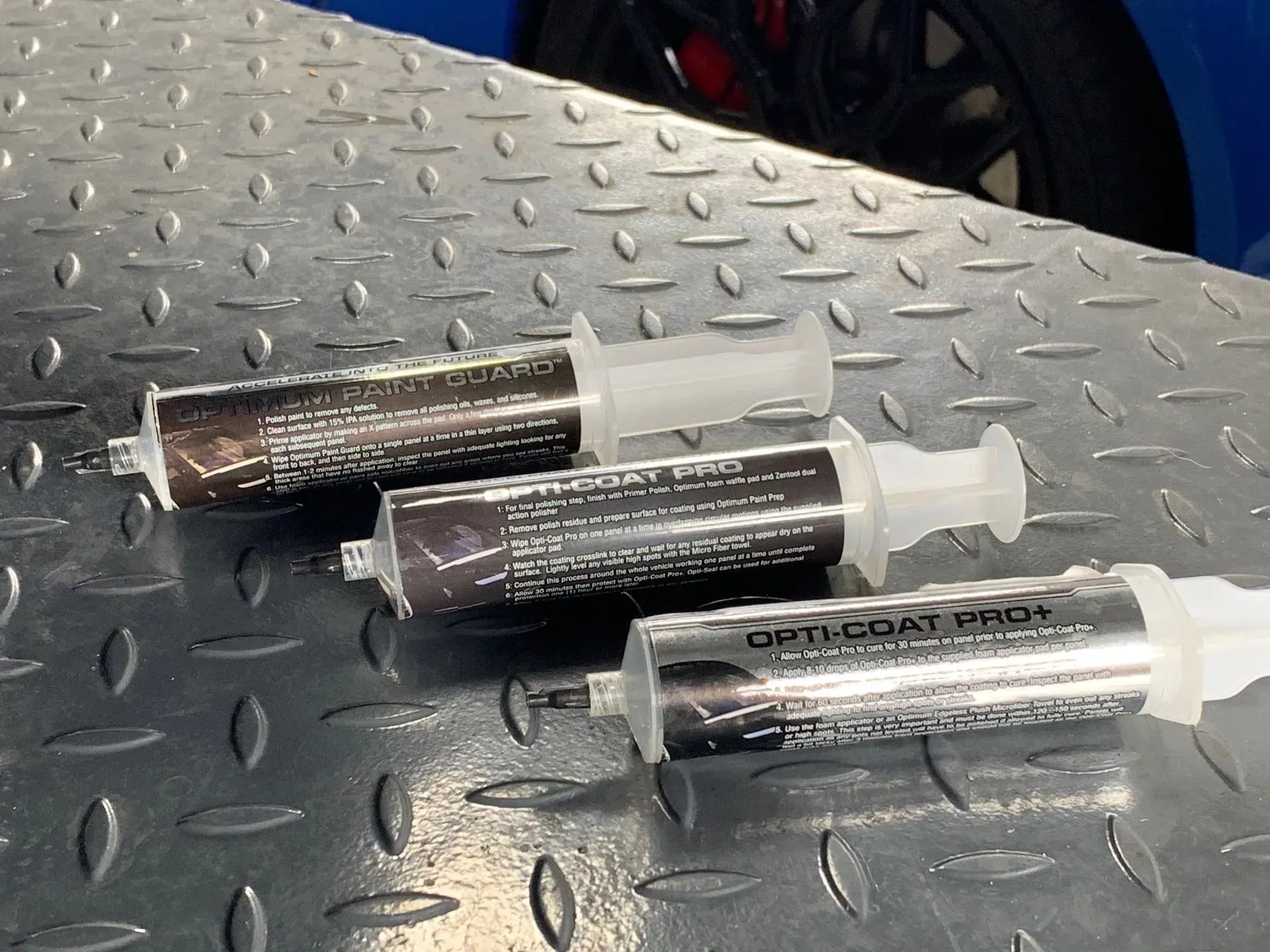Three syringes on a metal surface with one that says oxycoat only