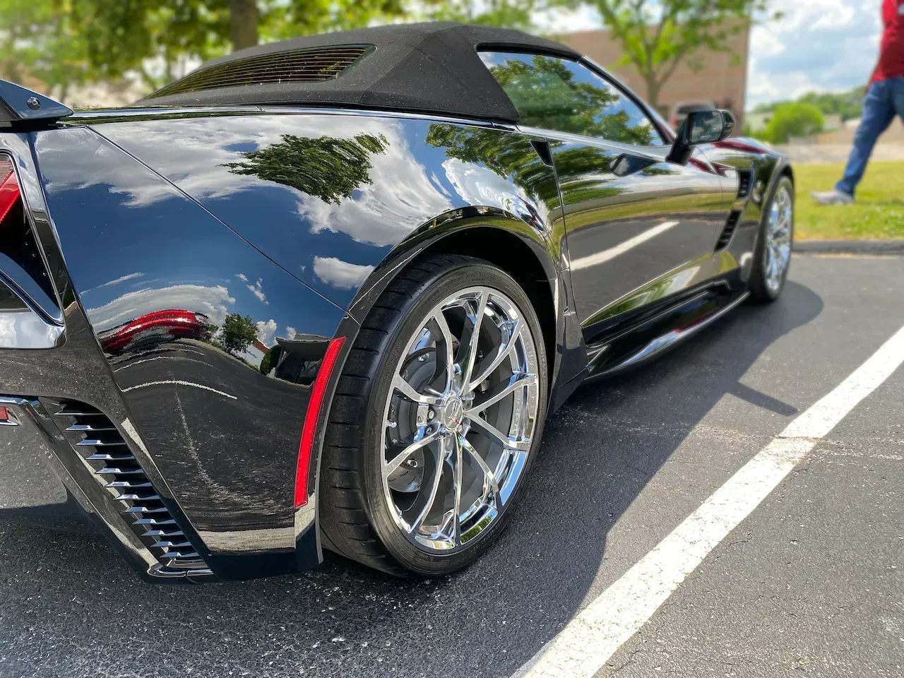 A black sports car is parked in a parking lot.