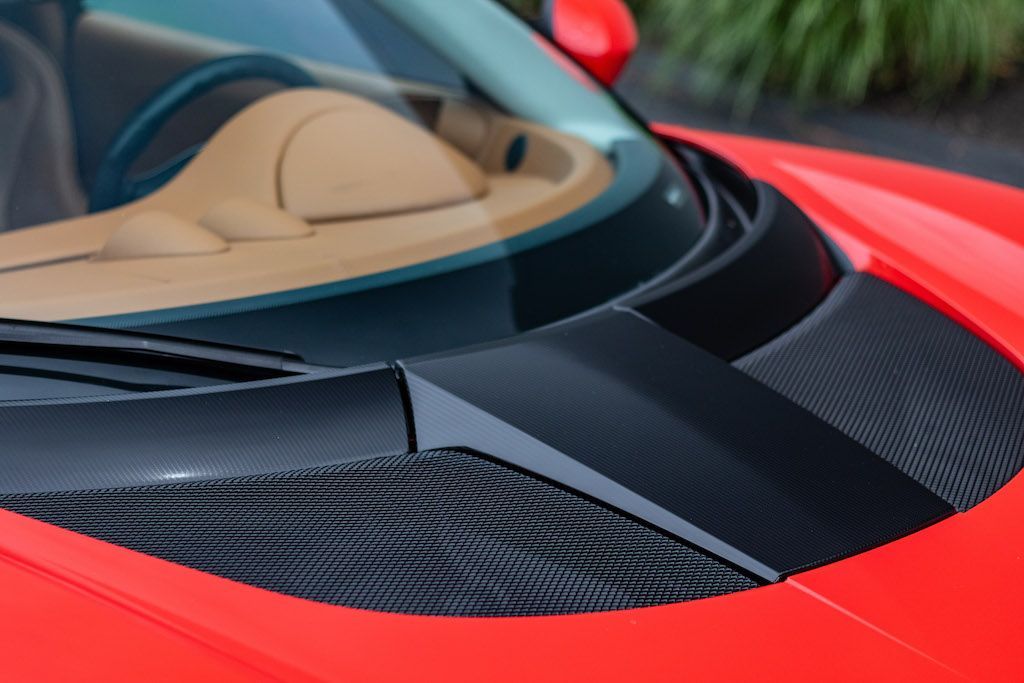 A close up of the hood of a red sports car