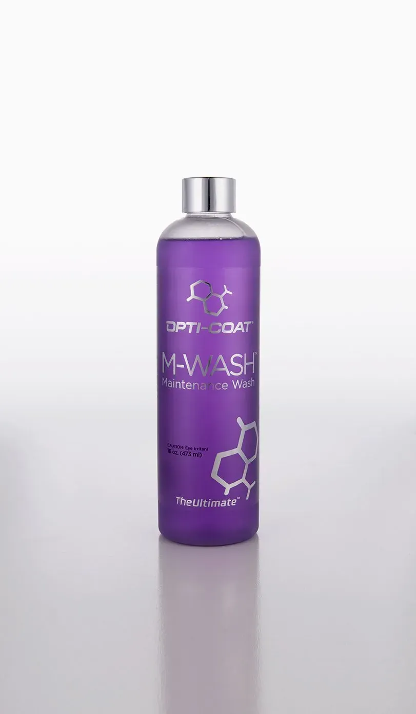 A purple bottle of shampoo is sitting on a white surface.