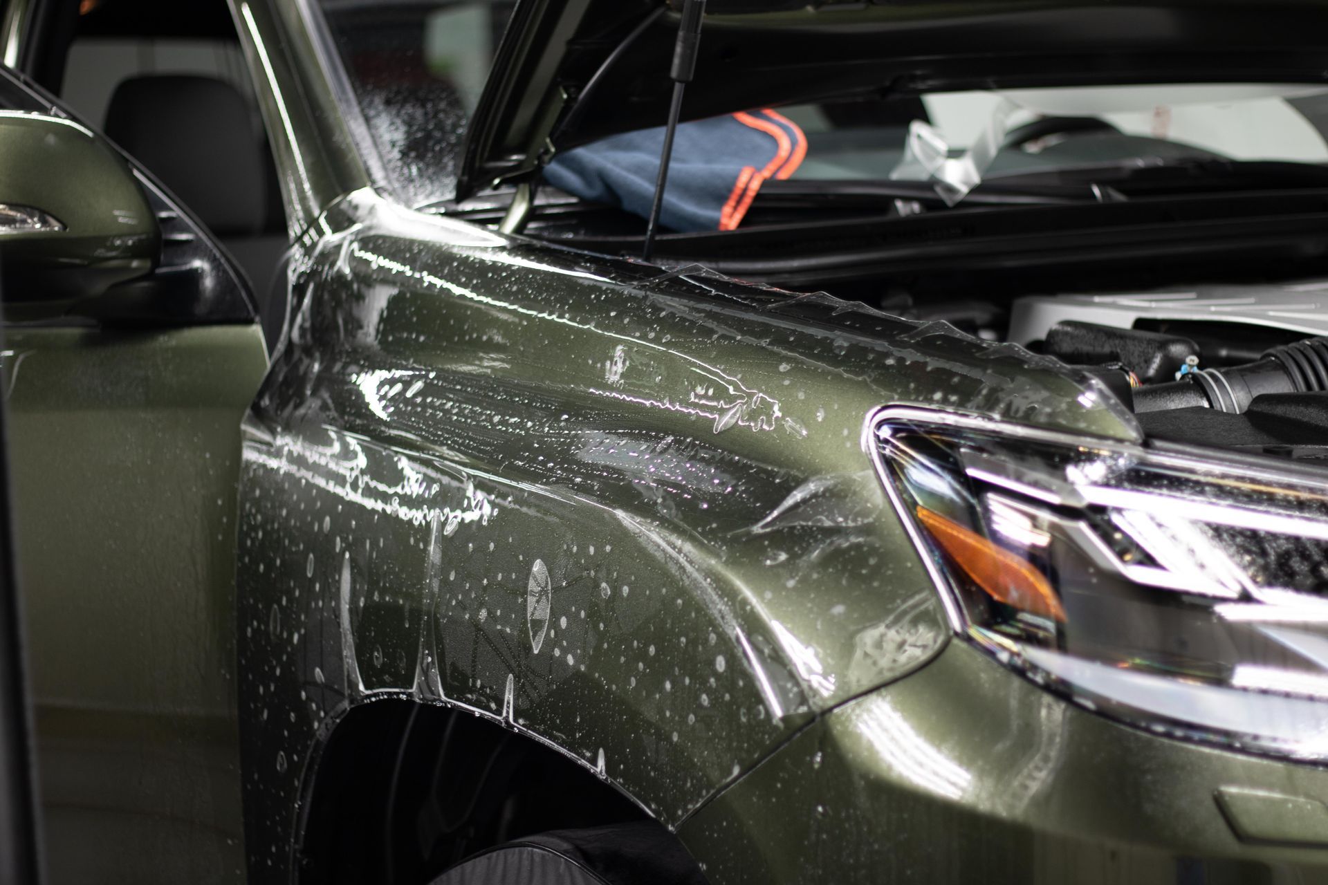 A close up of a car with a protective film on it.