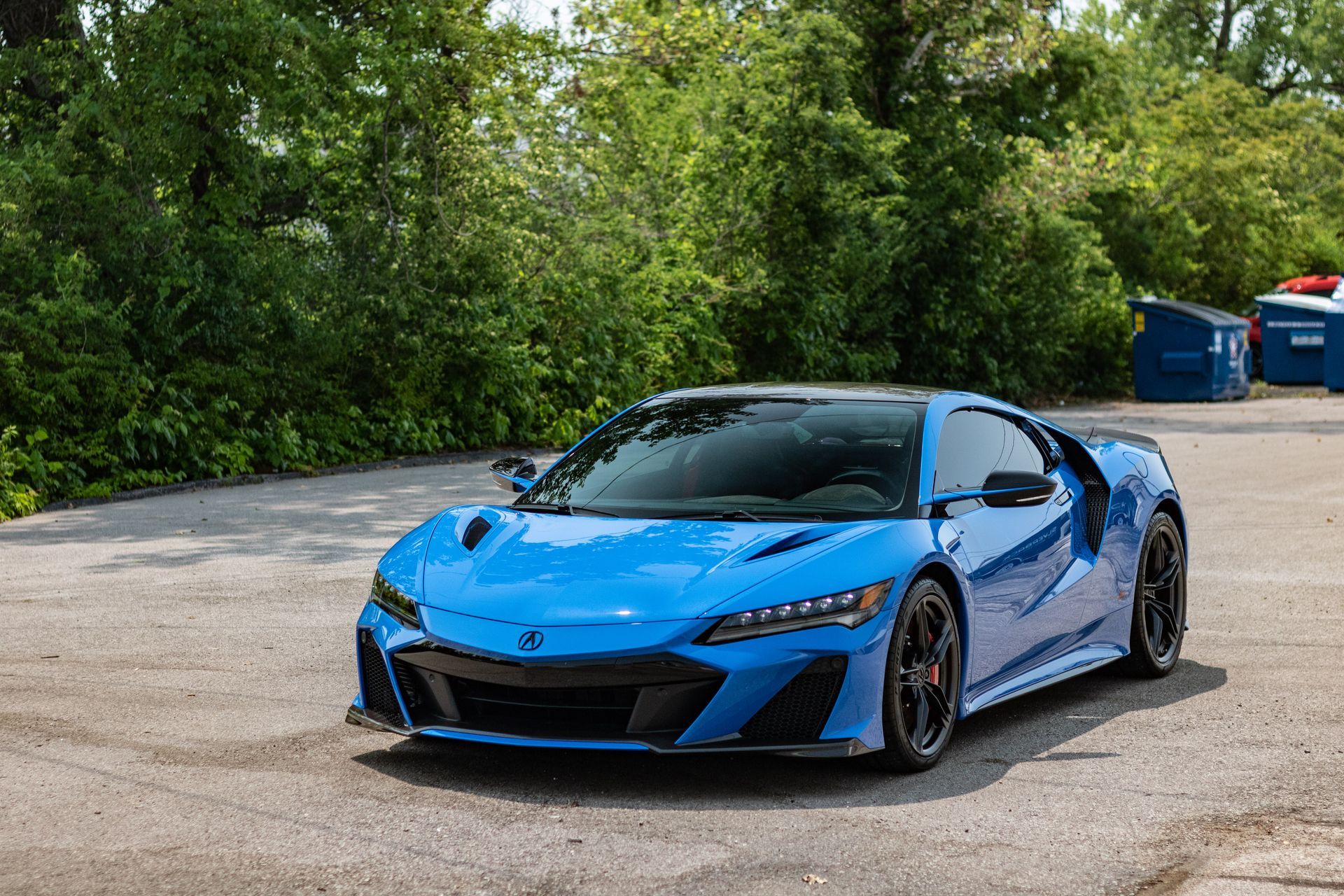 A blue sports car is parked in a parking lot.
