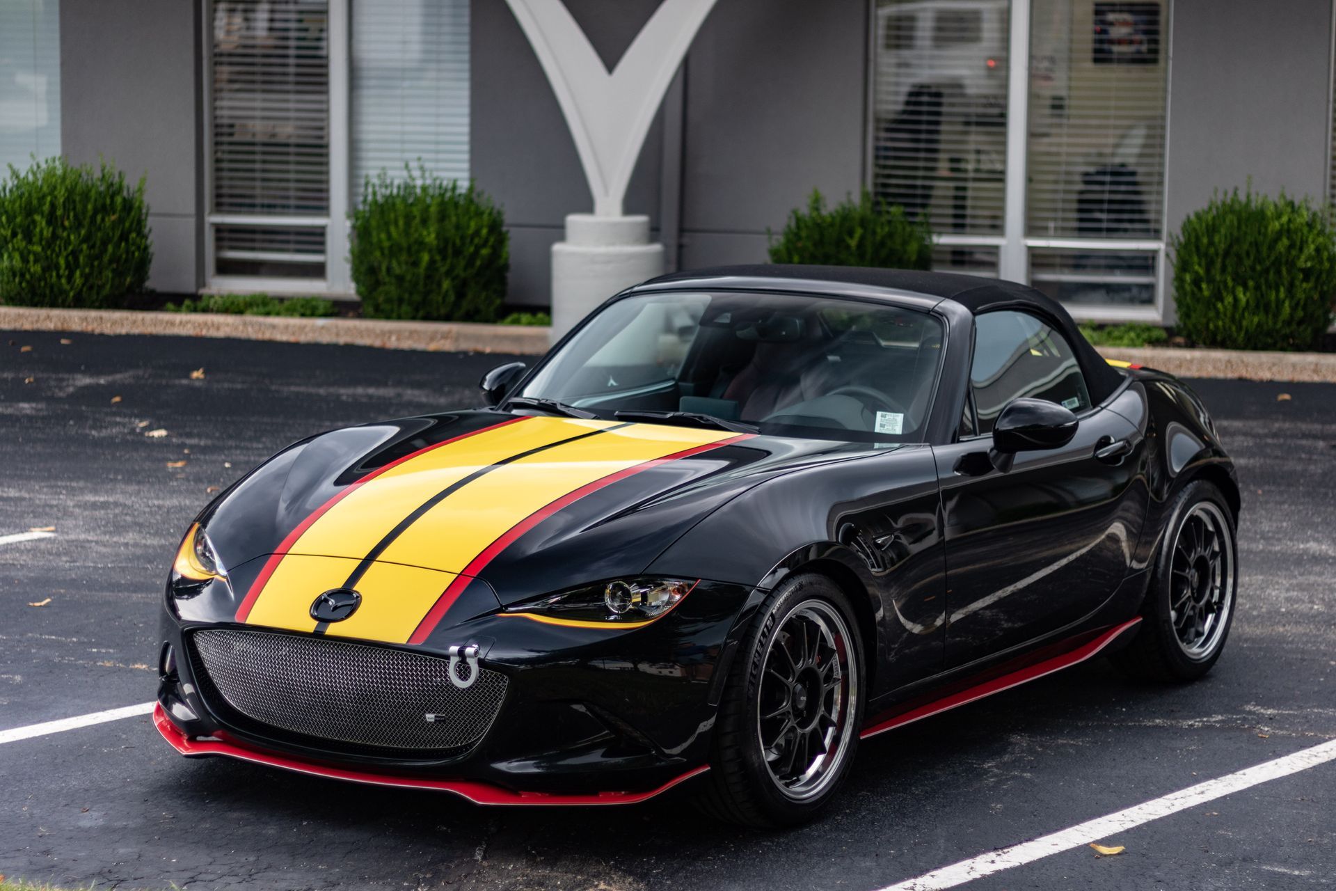 A black and yellow sports car is parked in a parking lot.