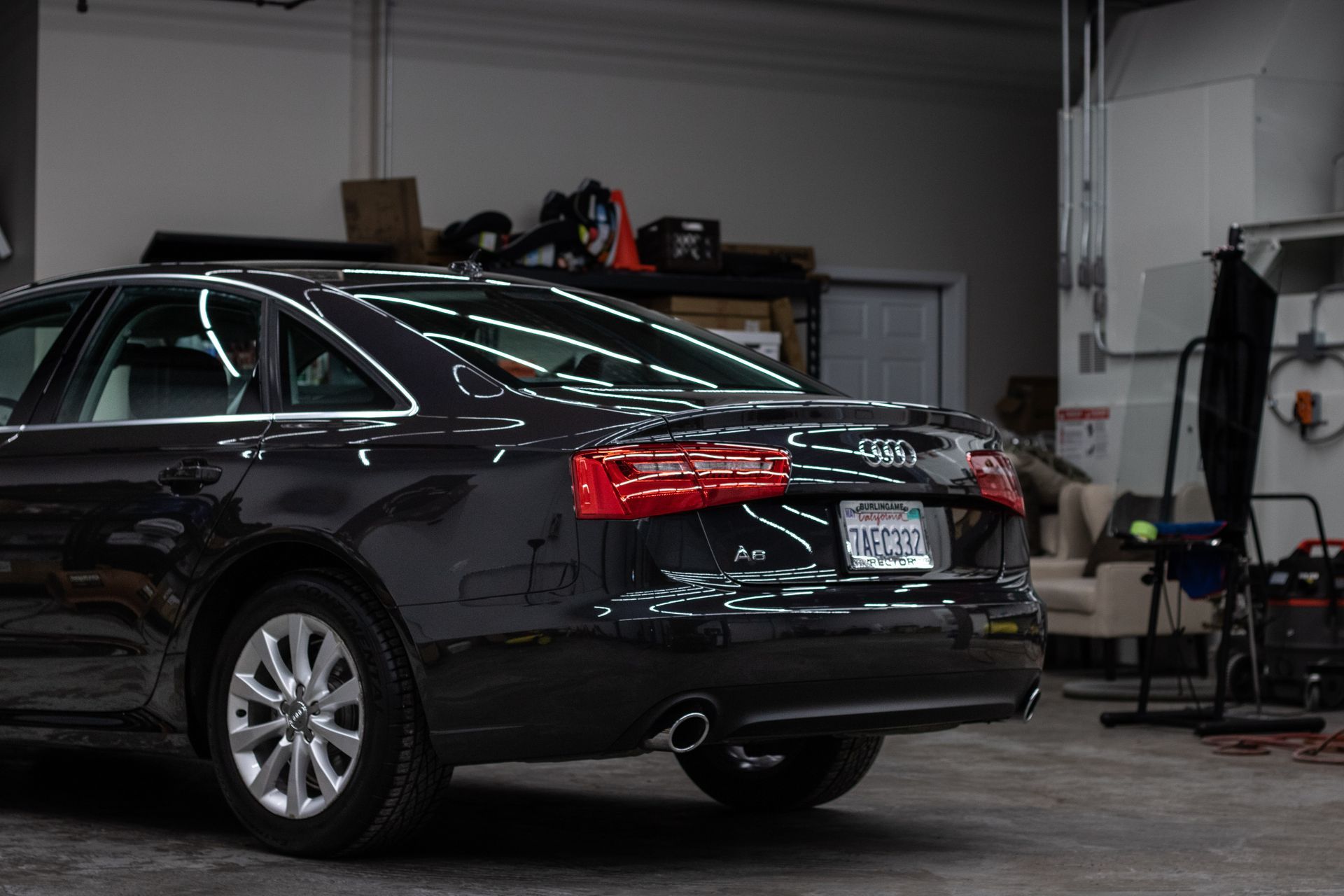 A black audi a6 is parked in a garage.
