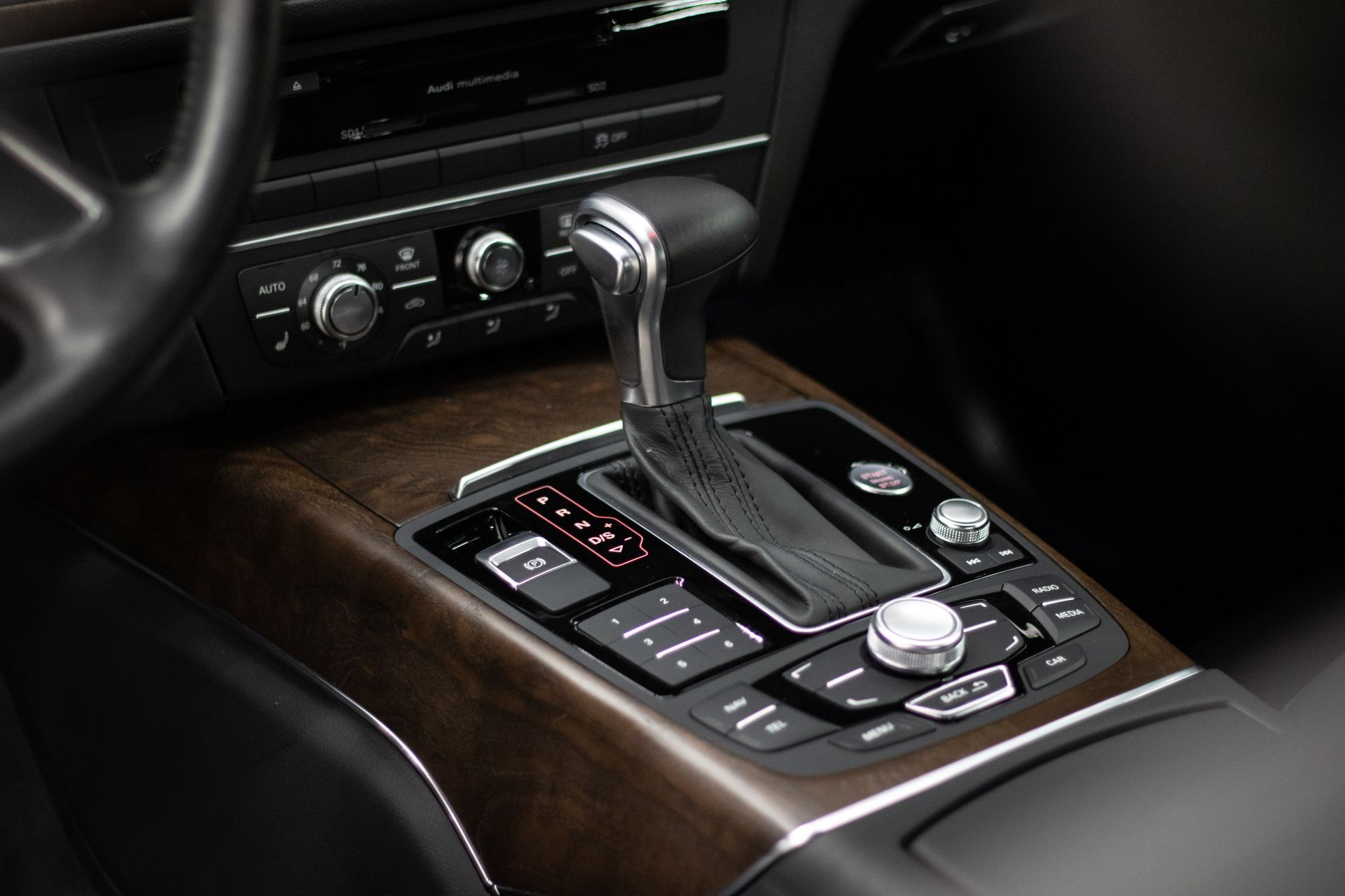 A close up of a car 's dashboard with a wooden trim.
