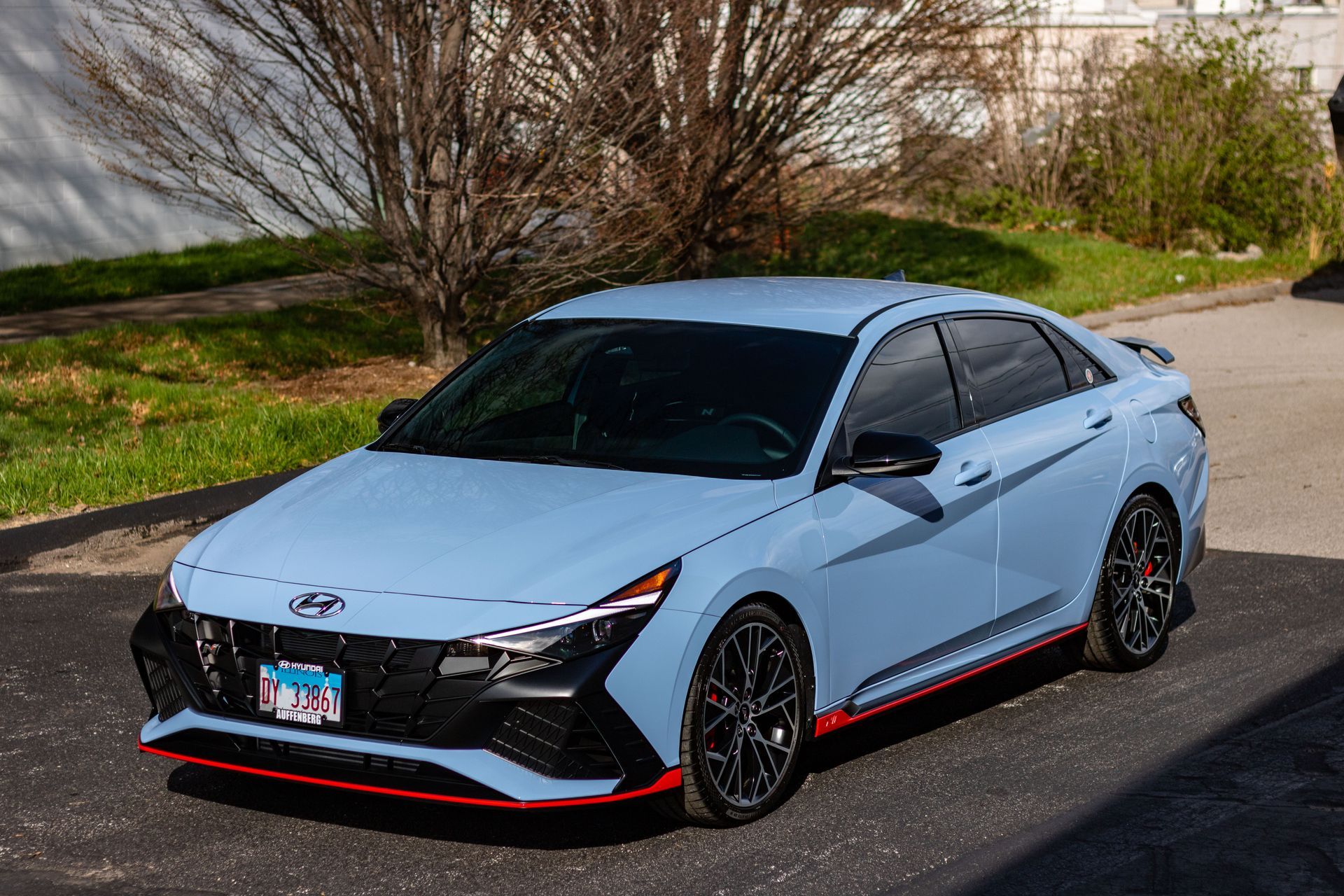 A blue hyundai elantra n line is parked on the side of the road.