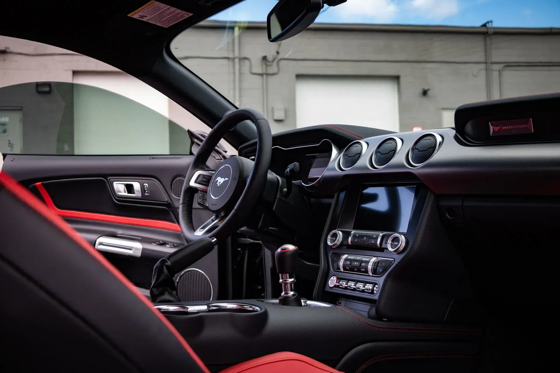 The interior of a ford mustang with red seats