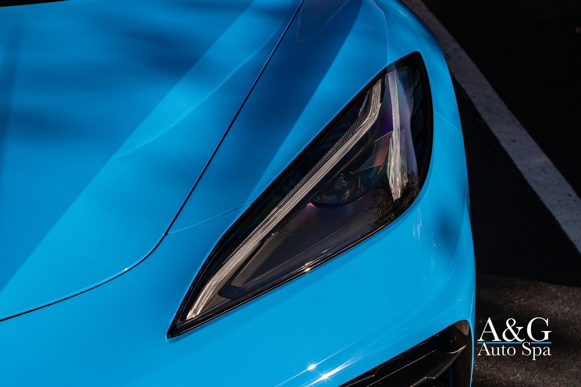A close up of the headlight of a blue sports car