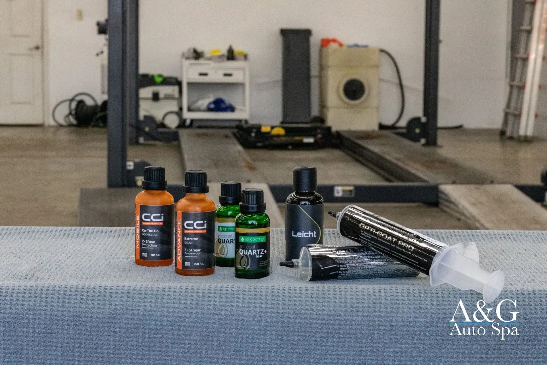 A group of bottles are sitting on a table in a garage.