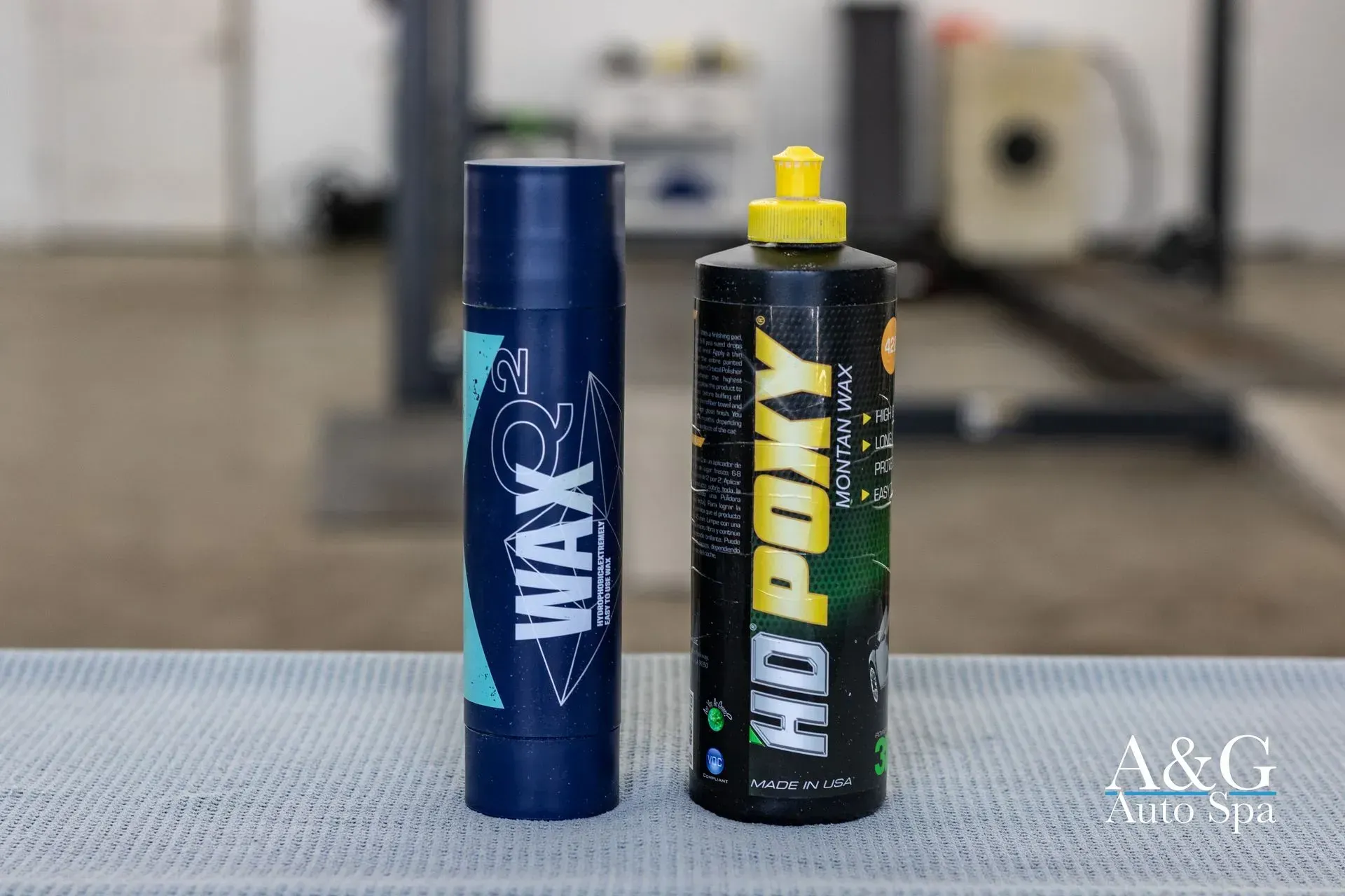 Two bottles of wax and polish are sitting on a table.