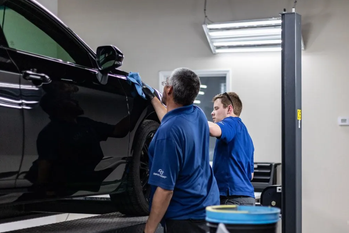 A man is working on a bmw in a garage.