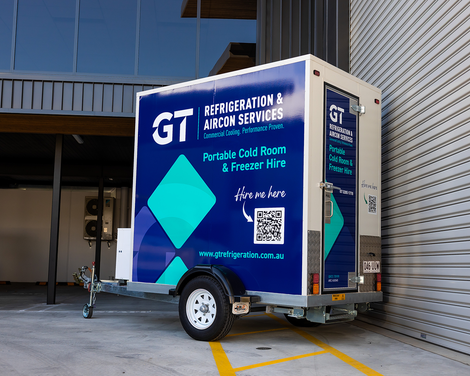 Blue refrigeration service trailer parked by a building, with company logo and QR code on the side.