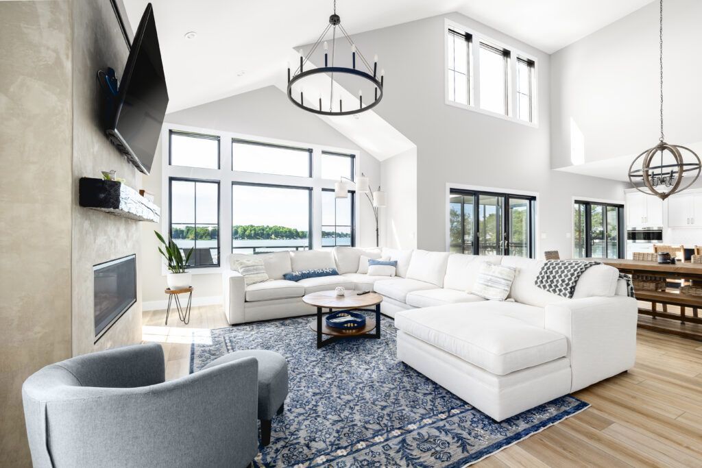 A living room with a large sectional couch , chair , coffee table and television.