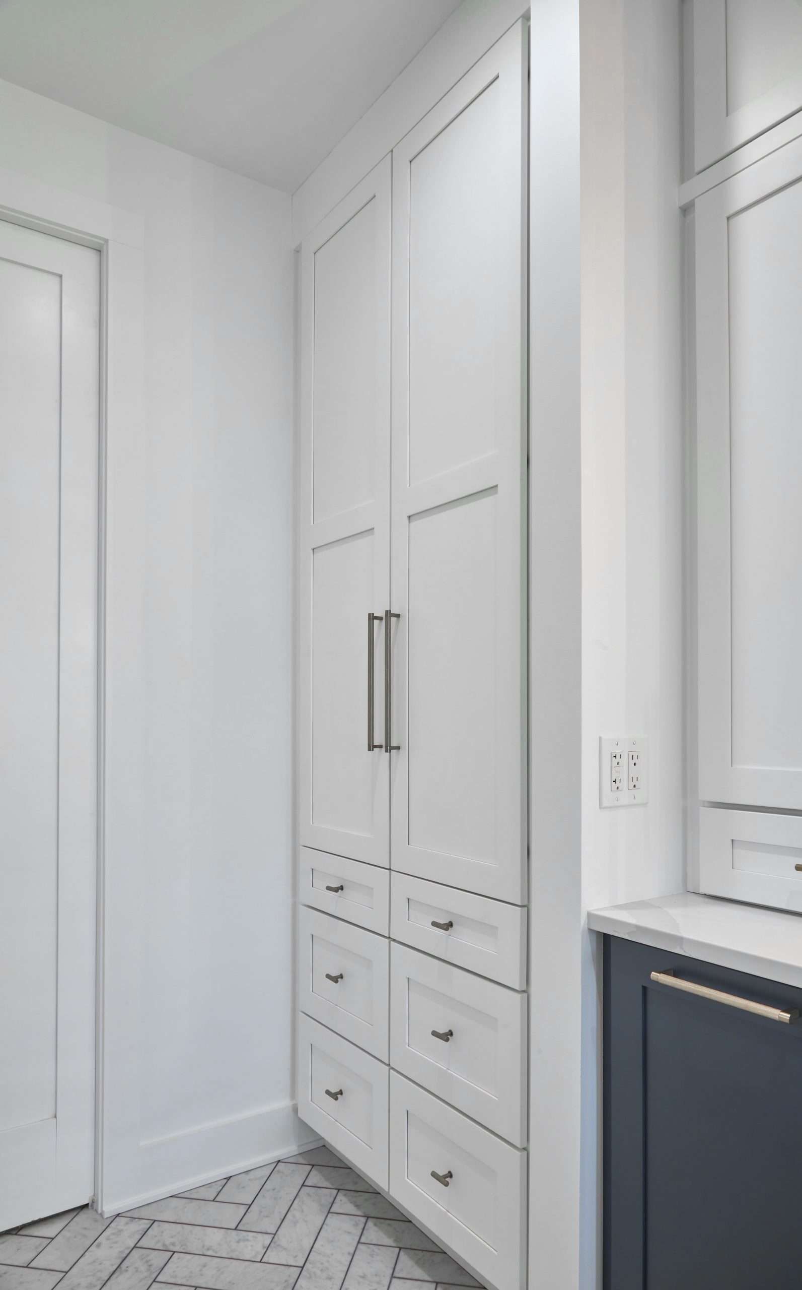 White built-in wardrobe with drawers in a bright bathroom or dressing area