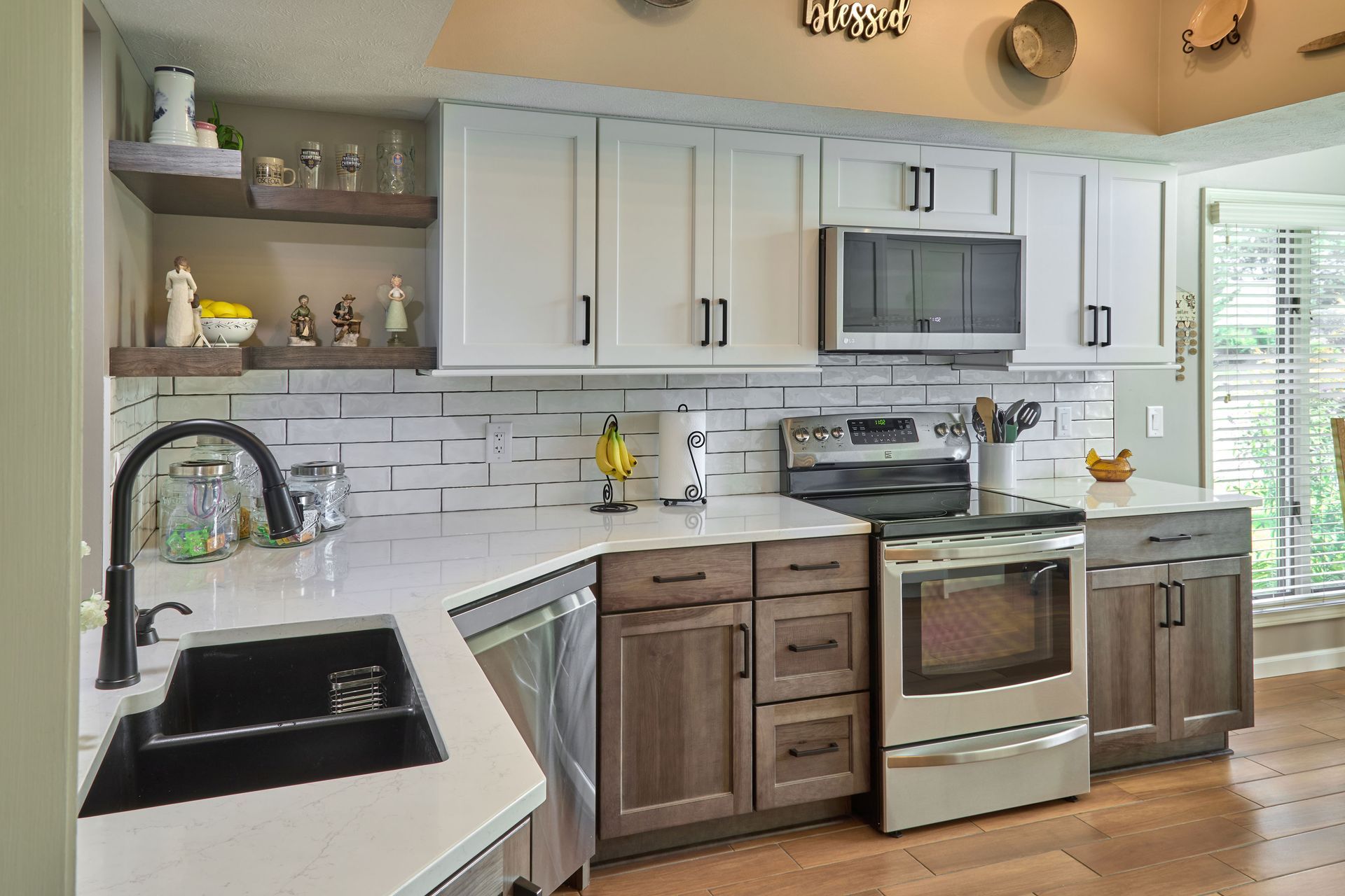 Modern kitchen with white cabinets, gray backsplash, stainless appliances, and farmhouse sink