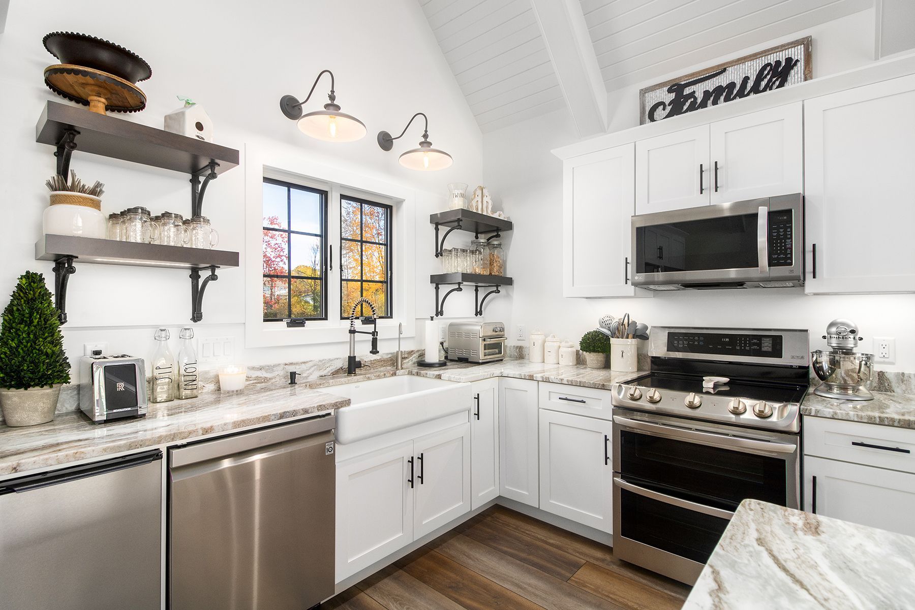 Bright white modern kitchen with stainless steel appliances, granite counters, and dark wood floors