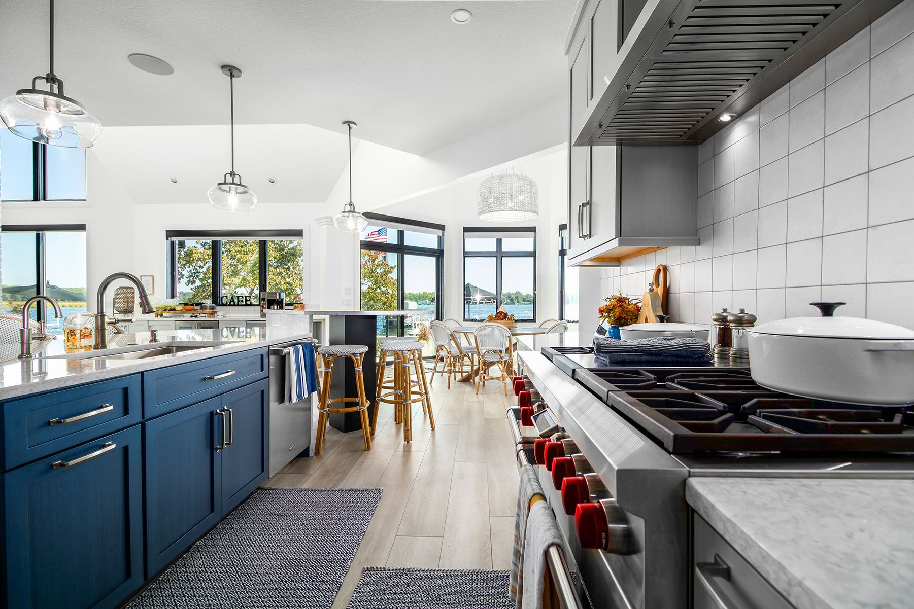 Modern kitchen with blue cabinets, large island, and stove under white tiled backsplash