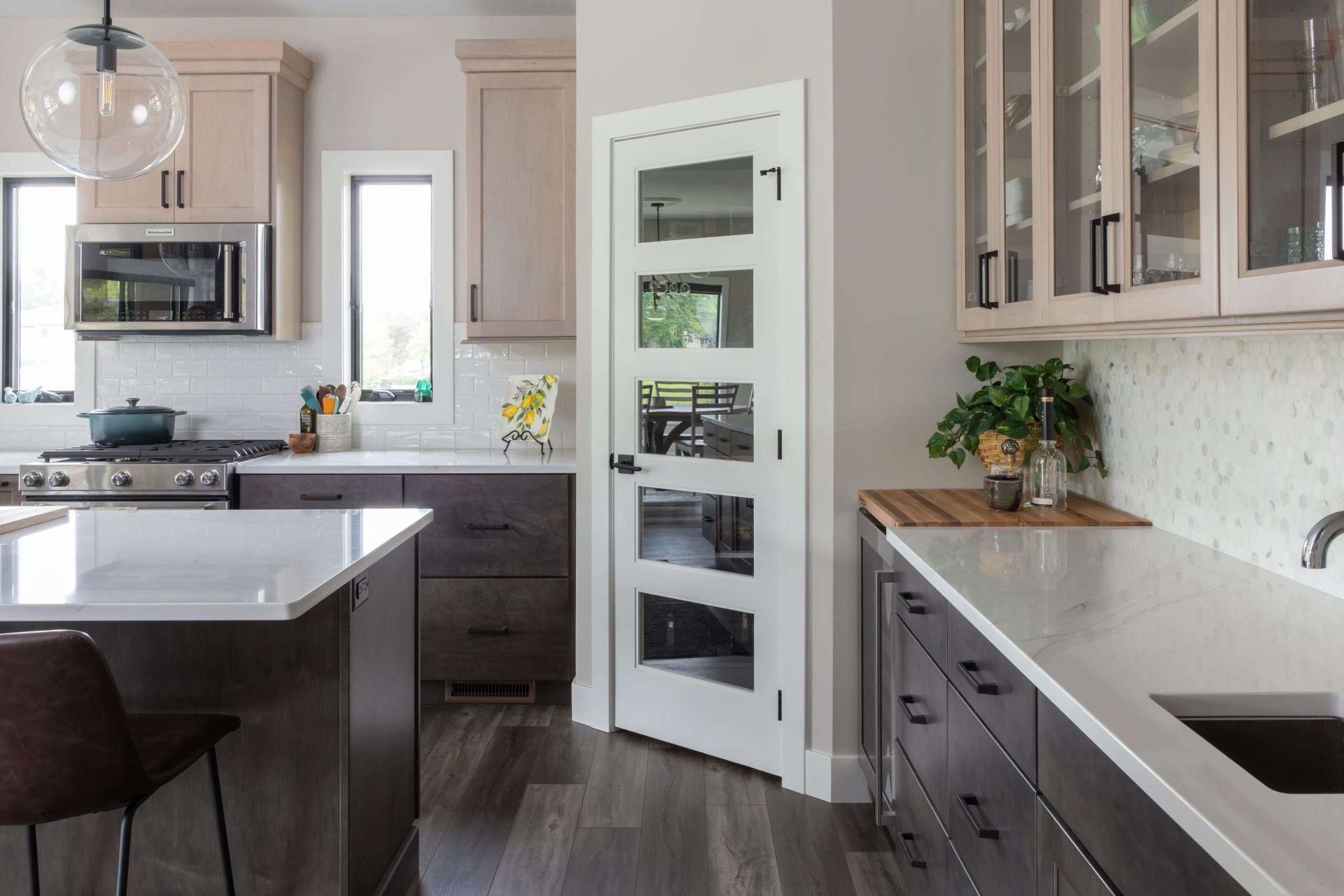 Modern kitchen with dark cabinets, white countertops, stainless appliances, and a central island