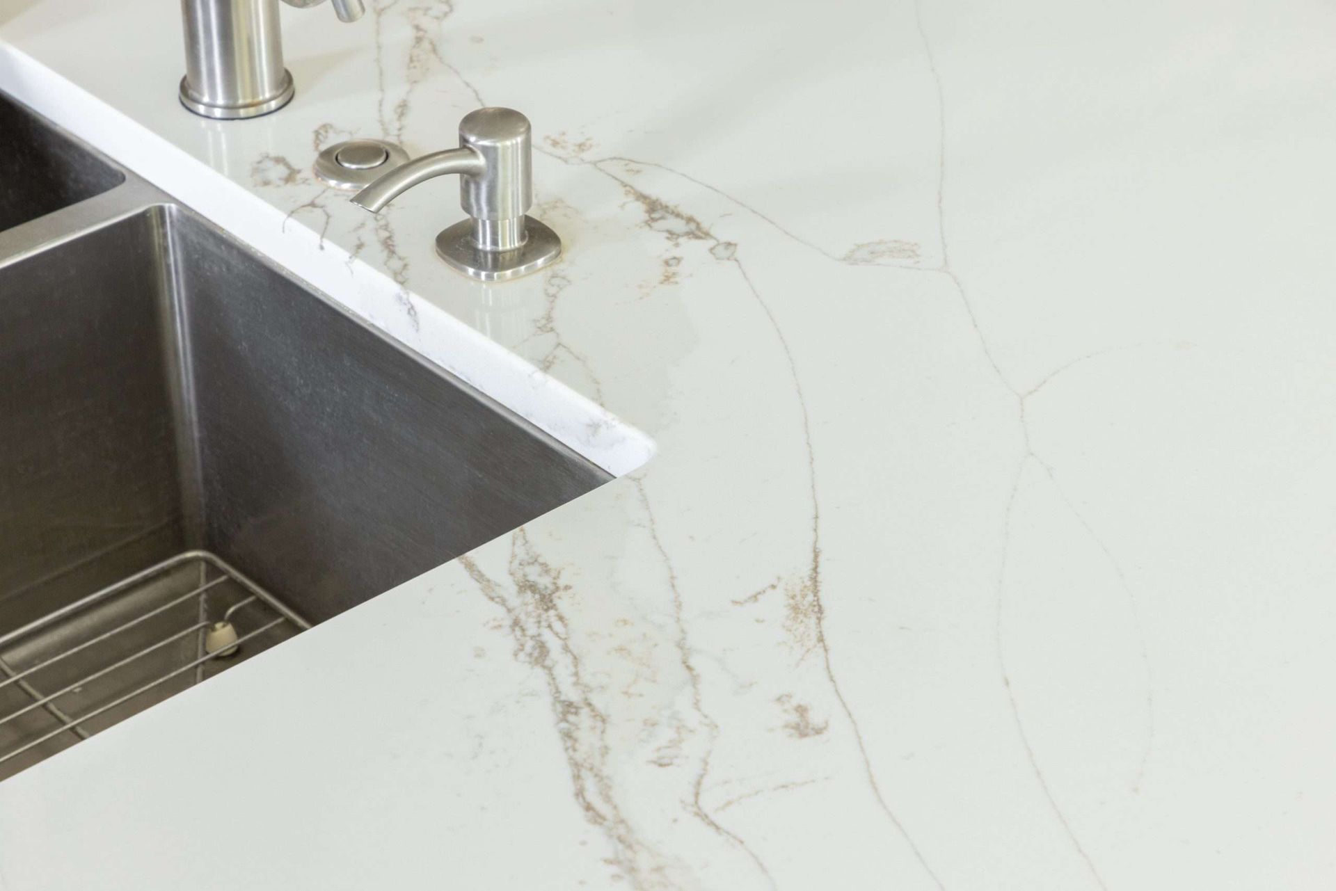 Modern kitchen countertop with stainless steel sink and faucet on white marble surface