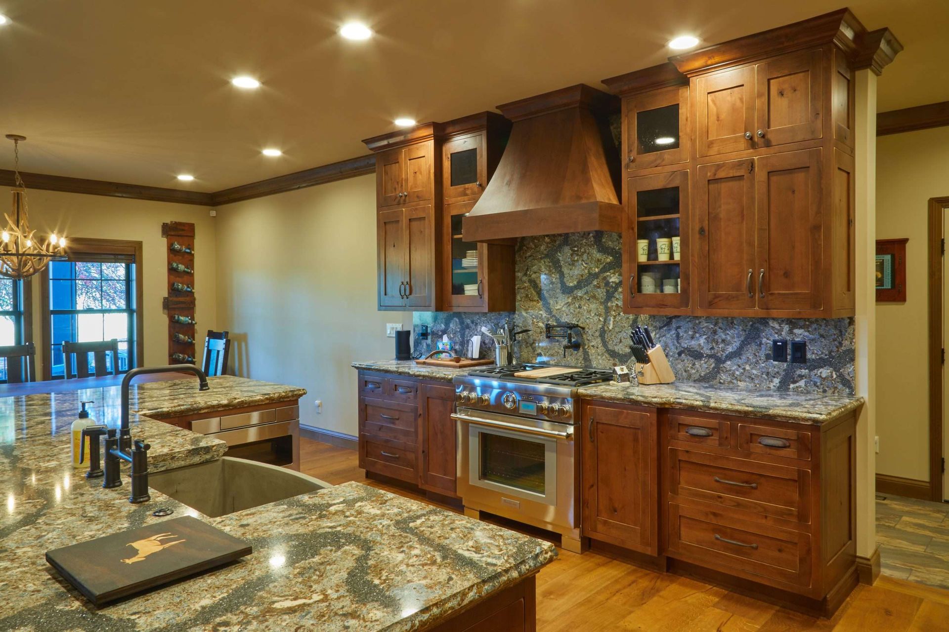 Spacious modern kitchen with granite counters, wood cabinets, and stainless steel appliances