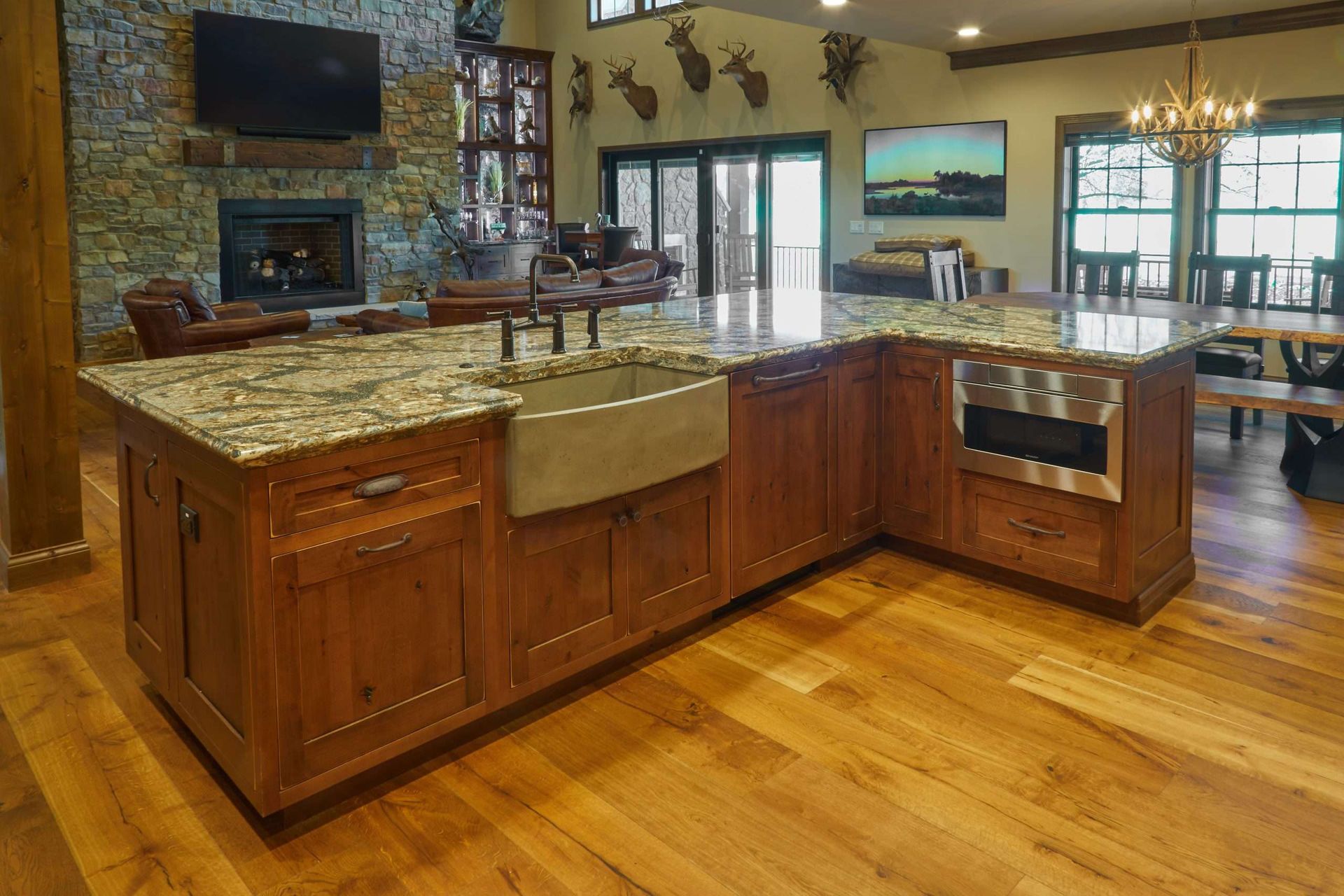Spacious kitchen with wooden cabinets, granite island, and hardwood floors in a warm, rustic home interior