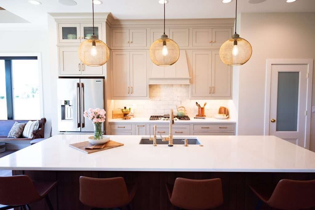 A kitchen with white cabinets , a sink , and a refrigerator.