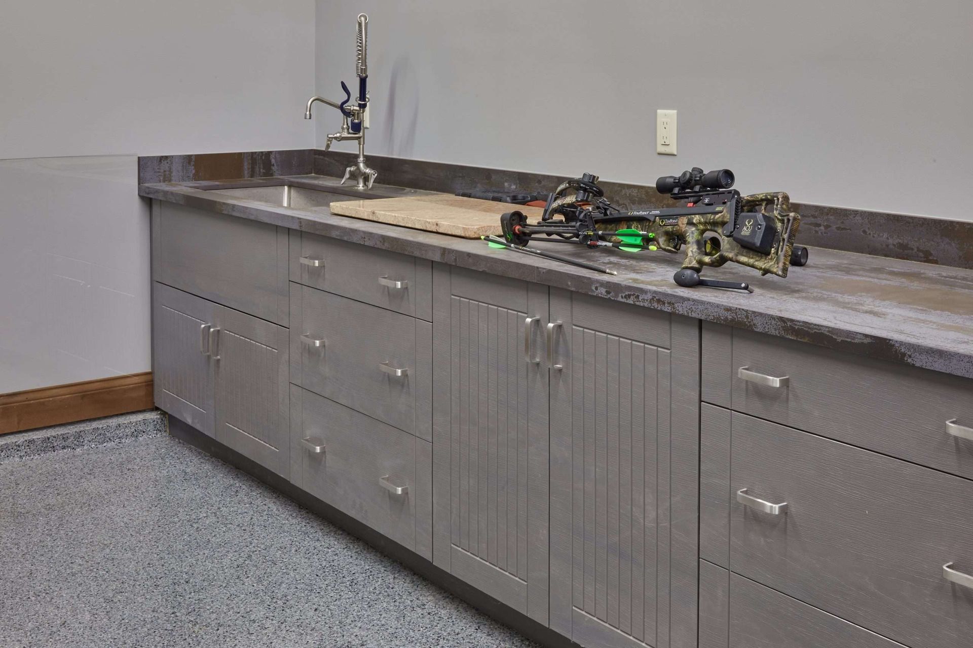 Gray lab cabinets with a sink and countertop equipment in a workshop or classroom setting