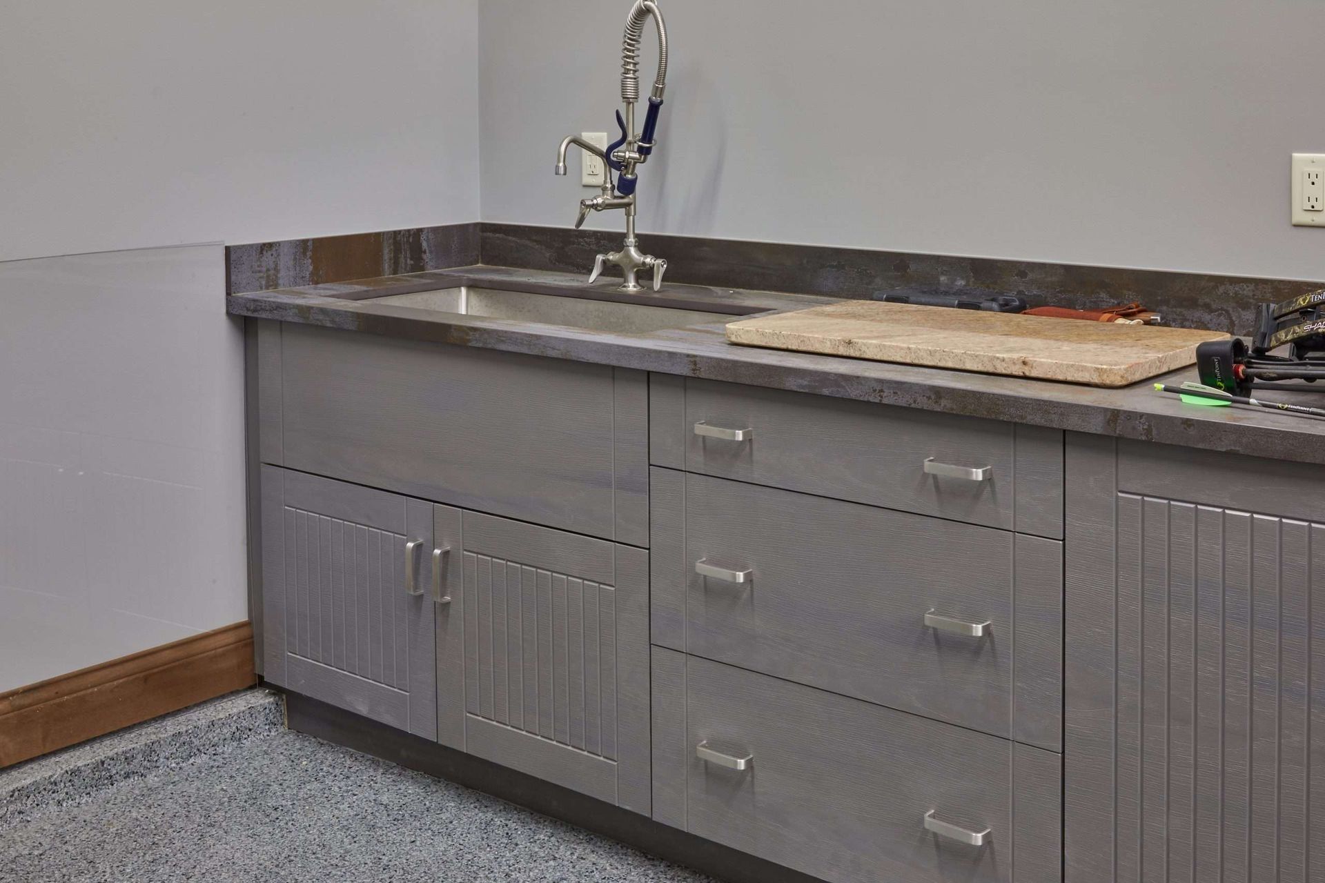 Gray utility cabinets with sink and countertop in a workshop or lab room