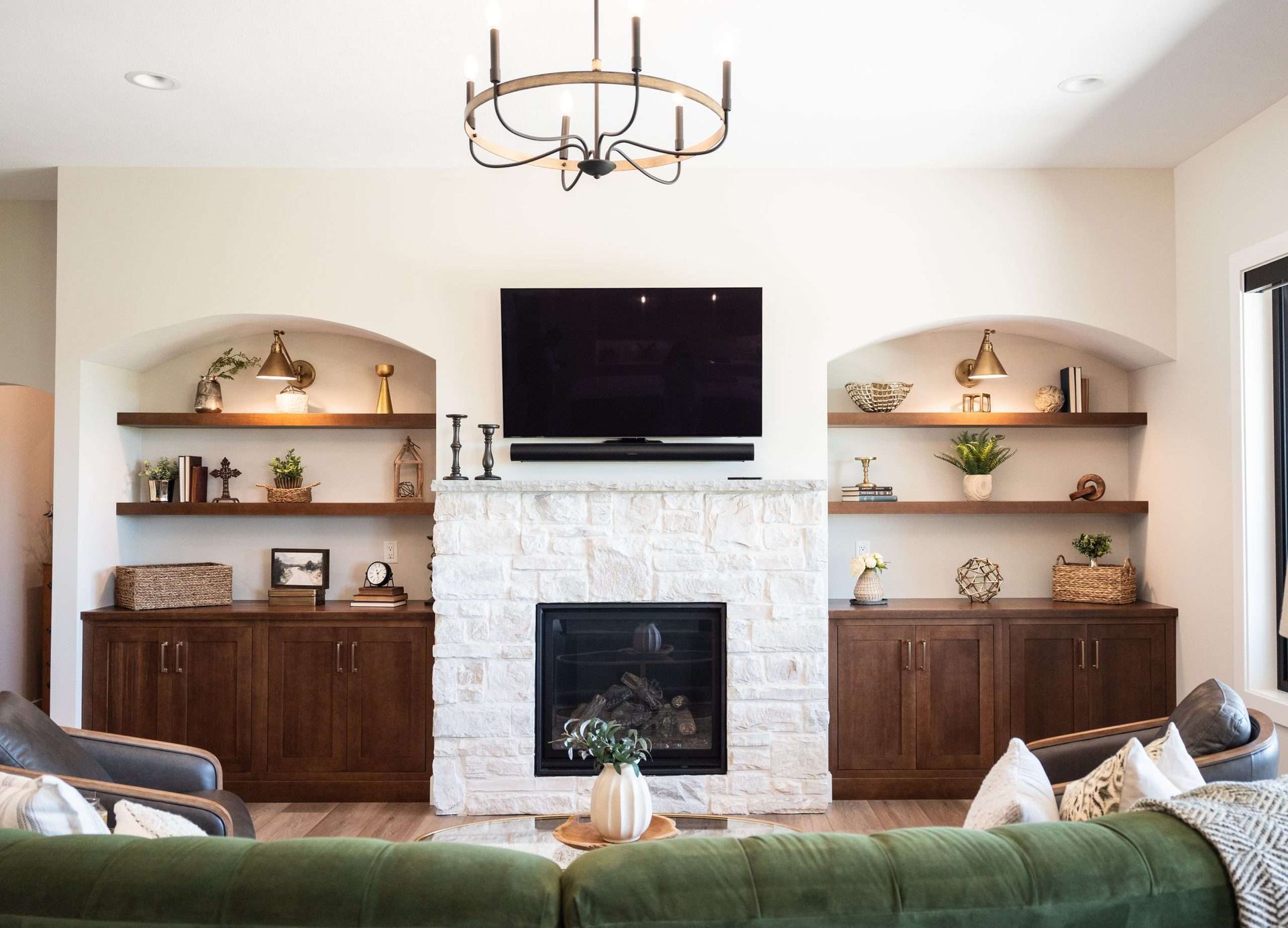 Cozy living room with a fireplace, wall-mounted TV, built-in shelves, and a green sofa