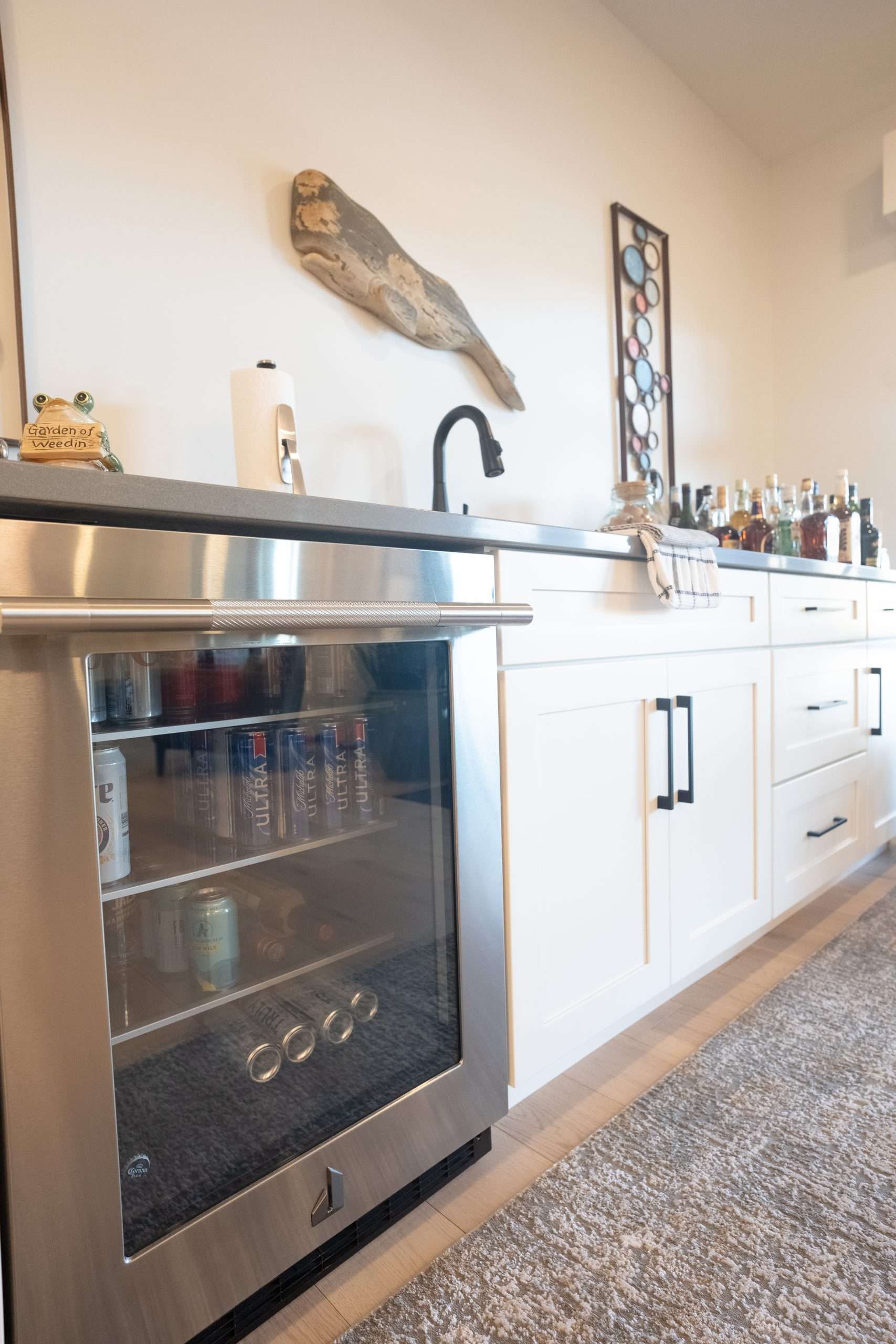 Modern kitchen with stainless steel oven, white cabinets, black faucet, and countertop decor