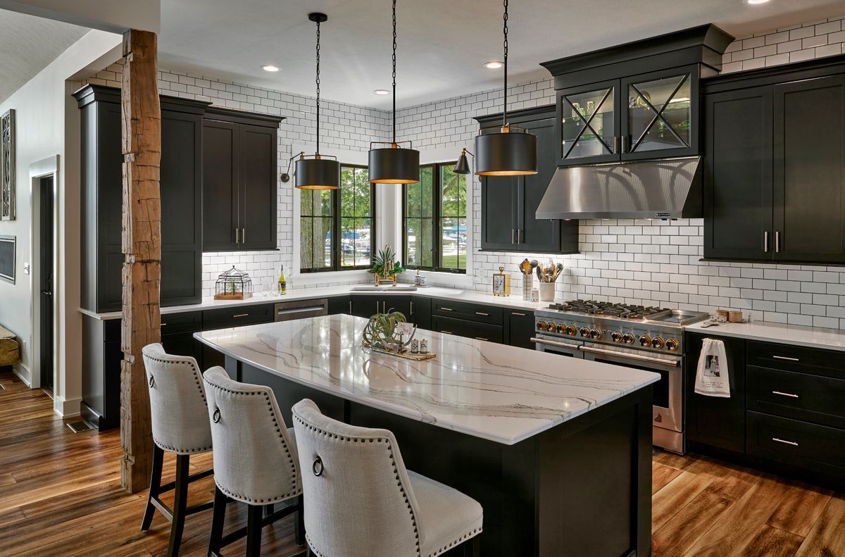 A kitchen with black cabinets and stainless steel appliances