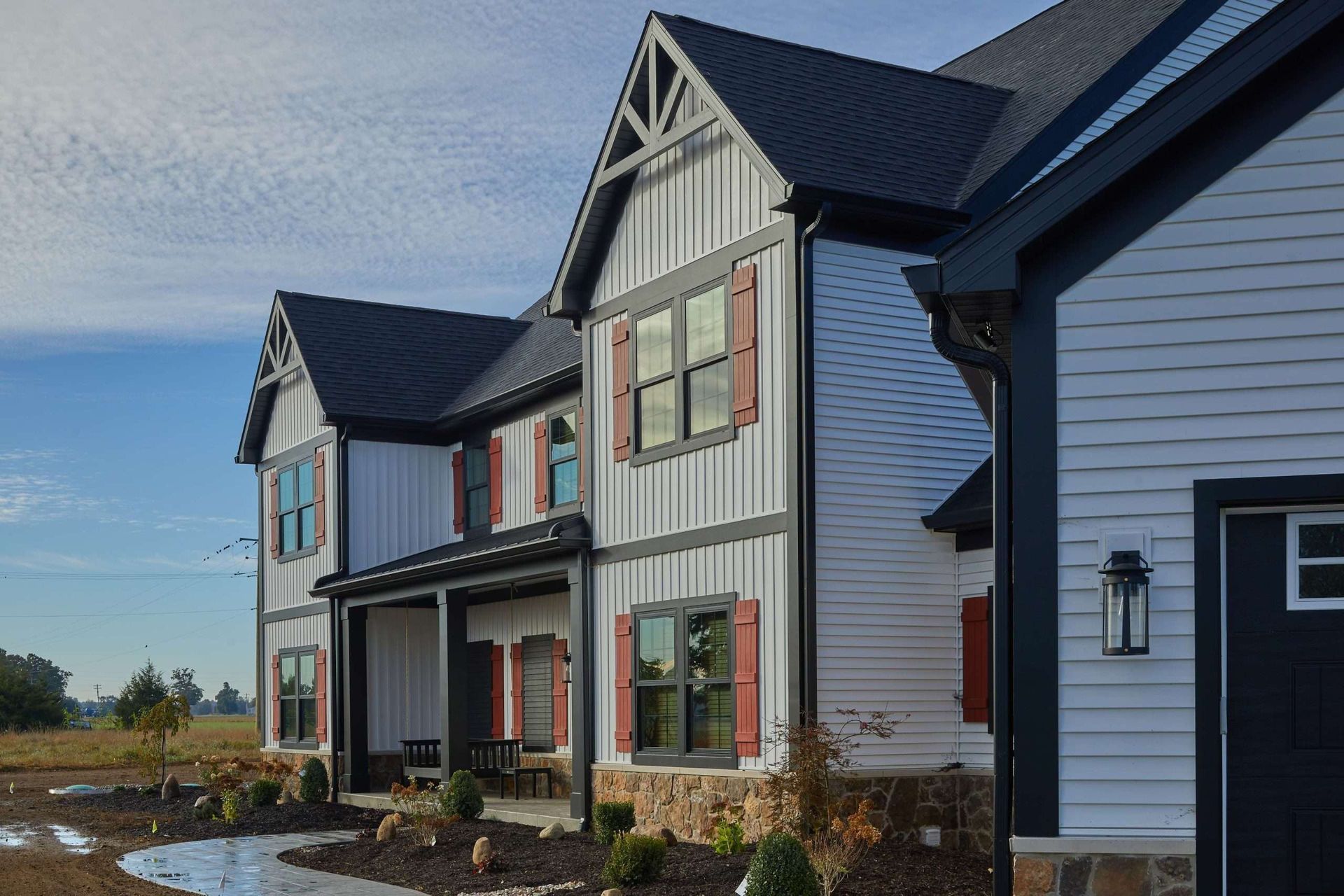 Row of modern gray townhouses with black roofs and white trim on a clear day