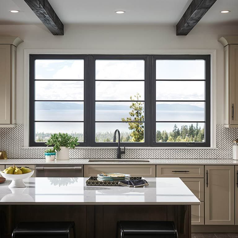 A kitchen with black cabinets and stainless steel appliances
