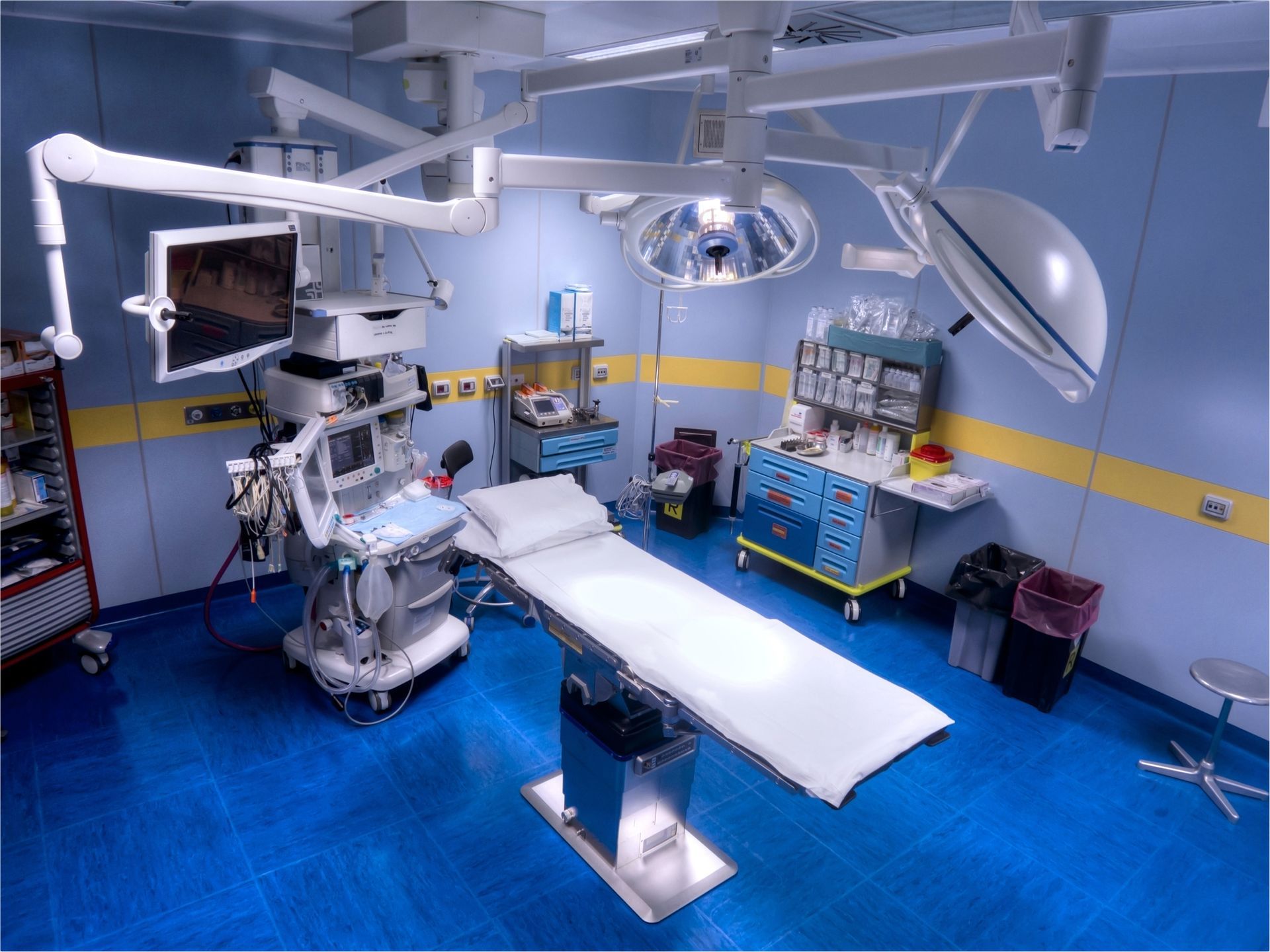 An operating room with a bed and a monitor