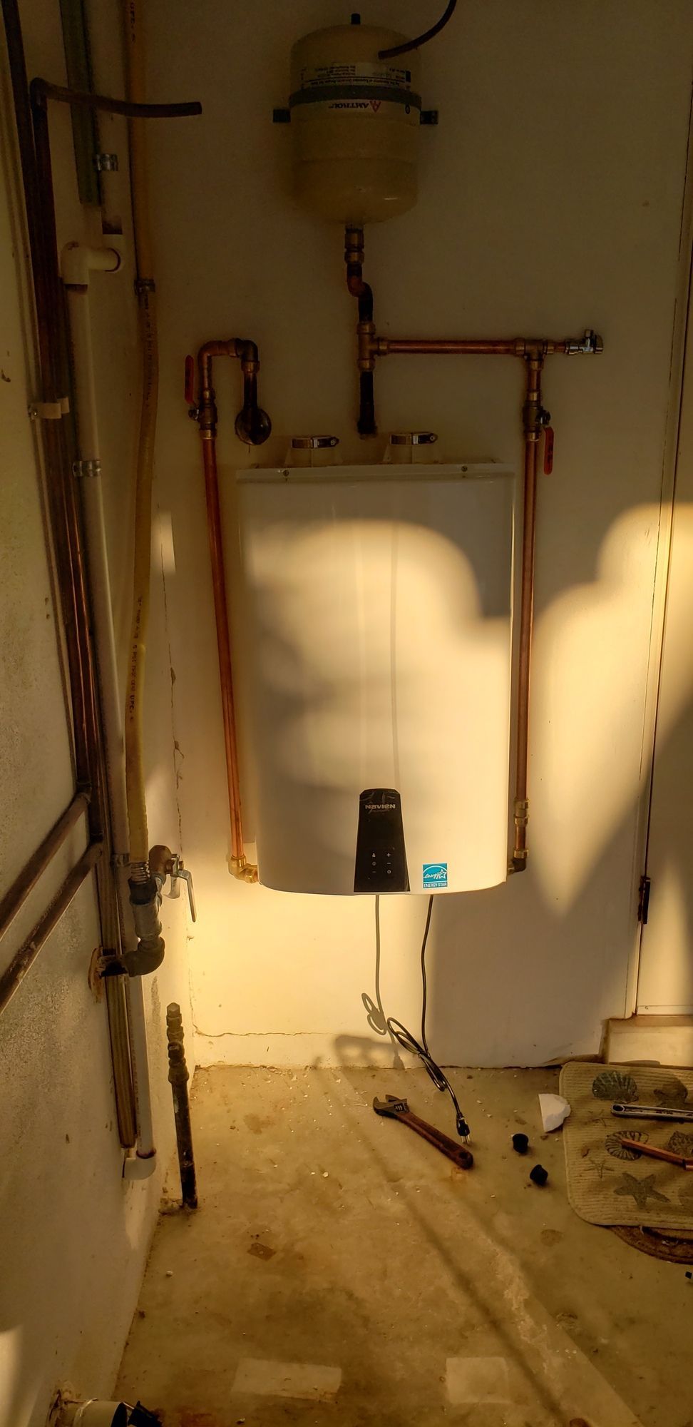 A room with a lot of pipes and a toilet in it.