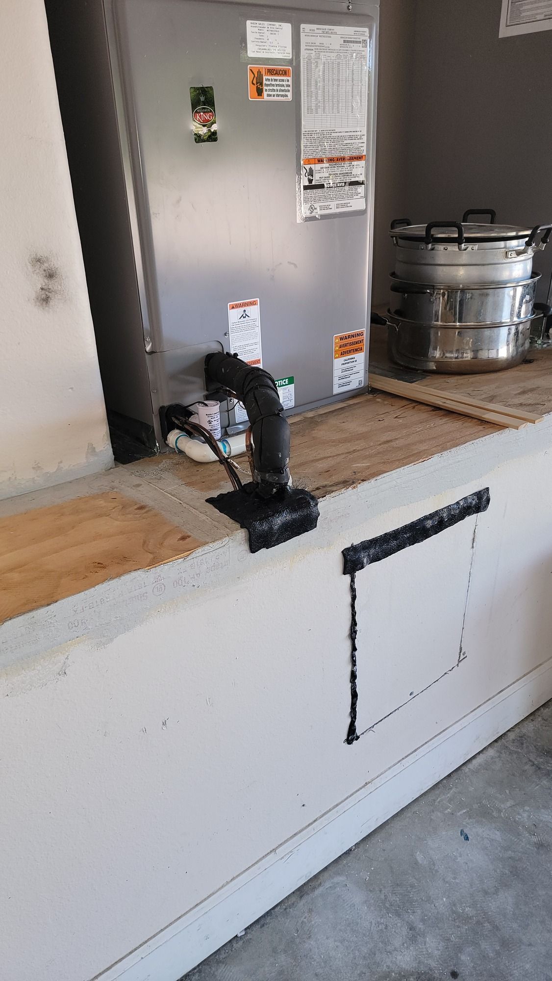 A refrigerator is sitting on top of a counter in a garage.
