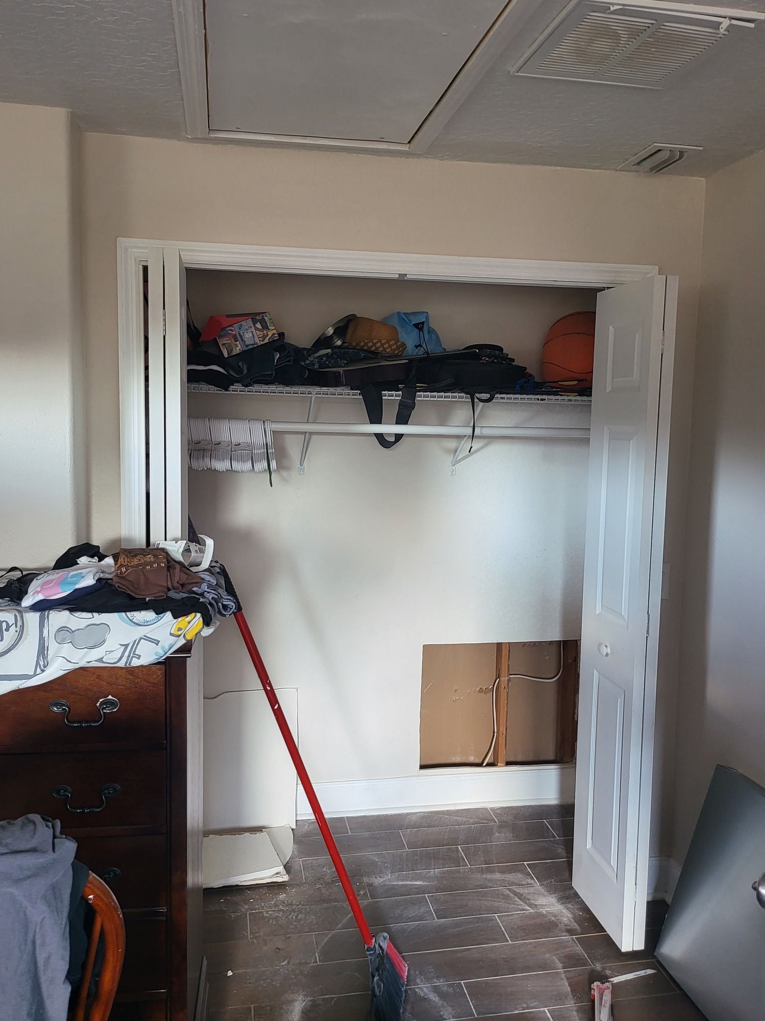 A room with a closet and a mop in it