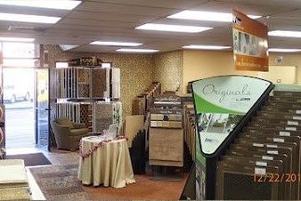 Interior of a flooring store, displays of tile and carpet samples.