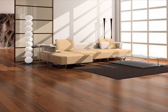 Modern living room with tan couch, hardwood floors, large window, and decorative floor lamp.