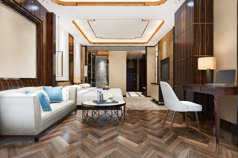 Luxurious hotel suite with a couch, desk, bed, and intricate wooden paneling.