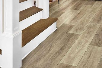 Wooden floor with matching stairs and white trim.