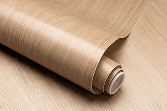 Rolled-up sheet of light-colored, wood-grain patterned vinyl flooring.