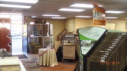 Interior of a carpet store with carpet samples, displays, and entrance.