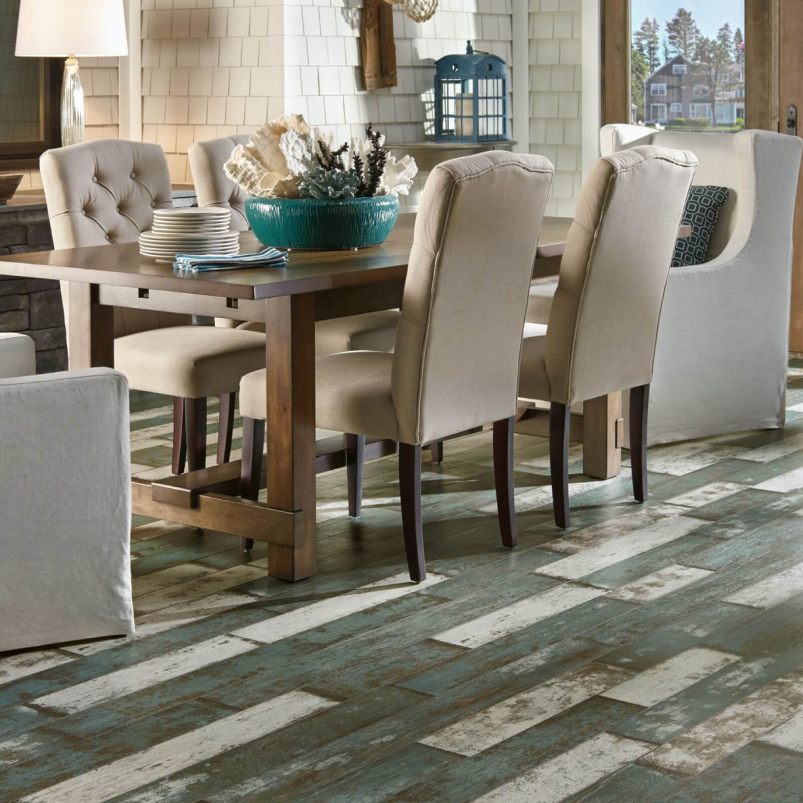 Dining room with rustic wood table, cream chairs, and distressed blue-white floor.