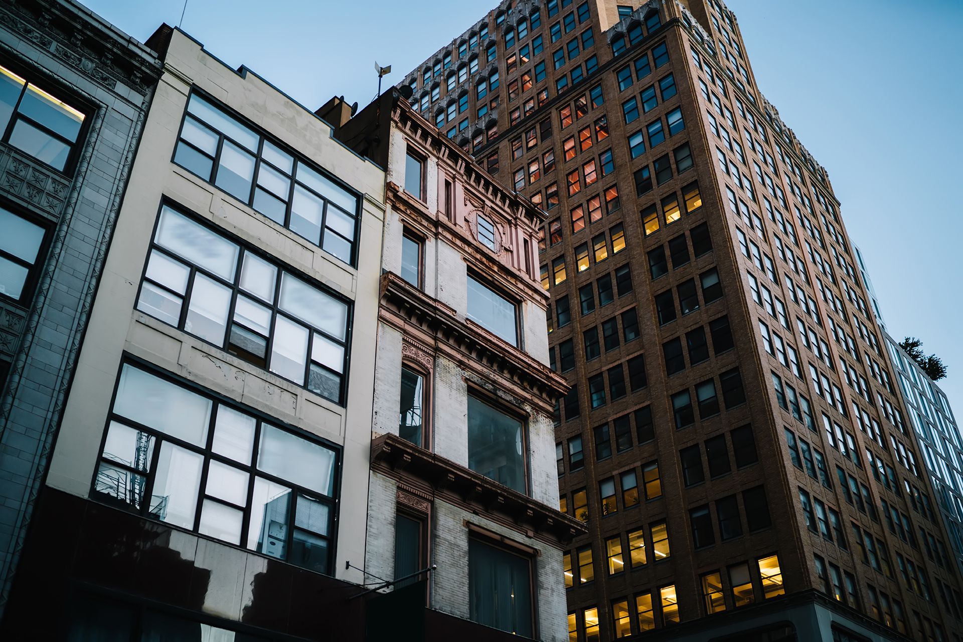 Looking up at a row of tall buildings with lots of windows.