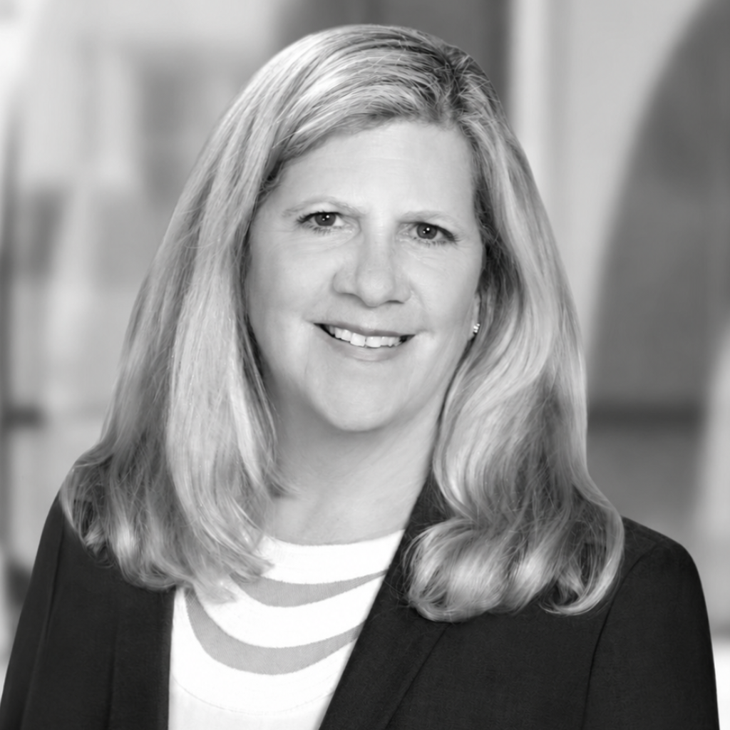 Portrait of a smiling woman in a blazer against a soft blurred background