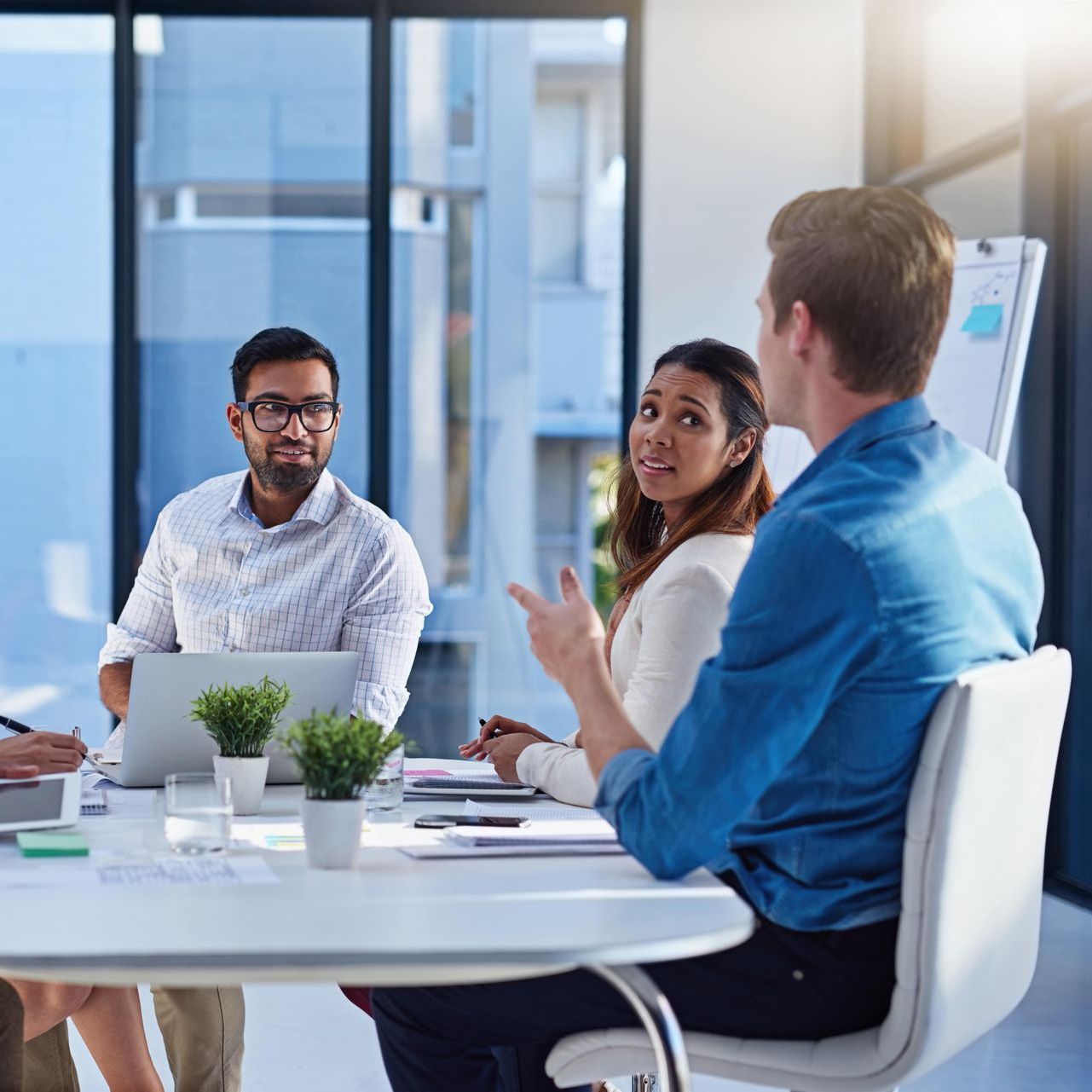 A group of people are sitting around a table having a meeting.