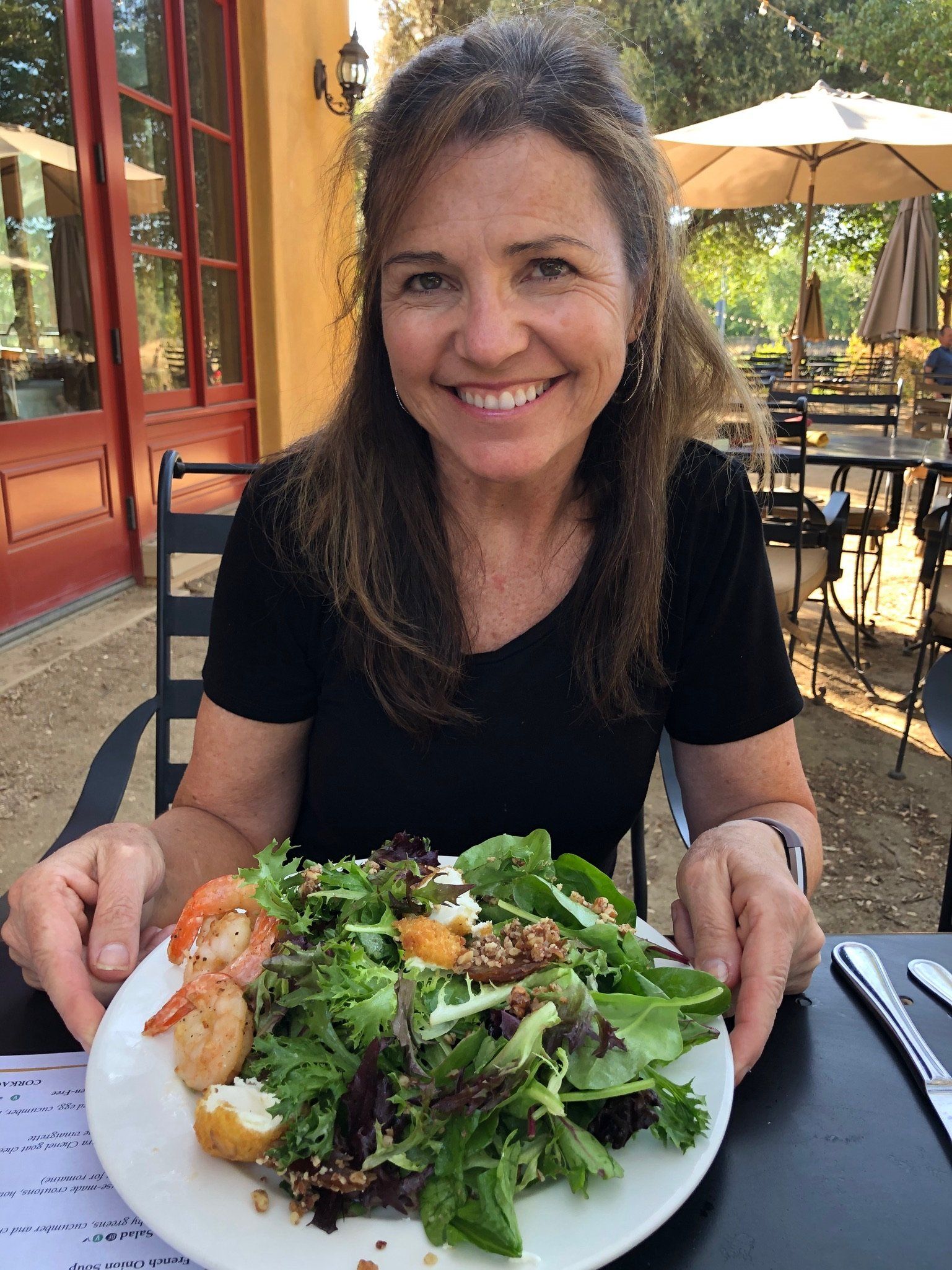 Jeanette showing a beautiful green salad on a white  plate.