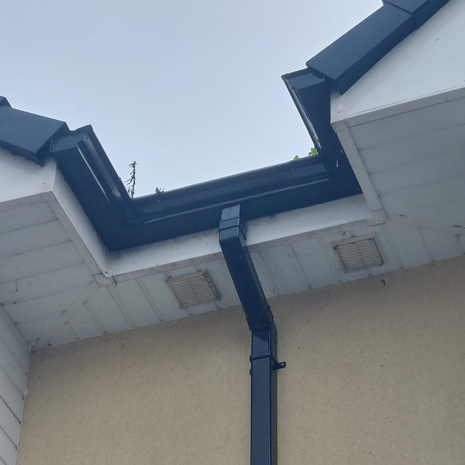 A black gutter on the side of a building