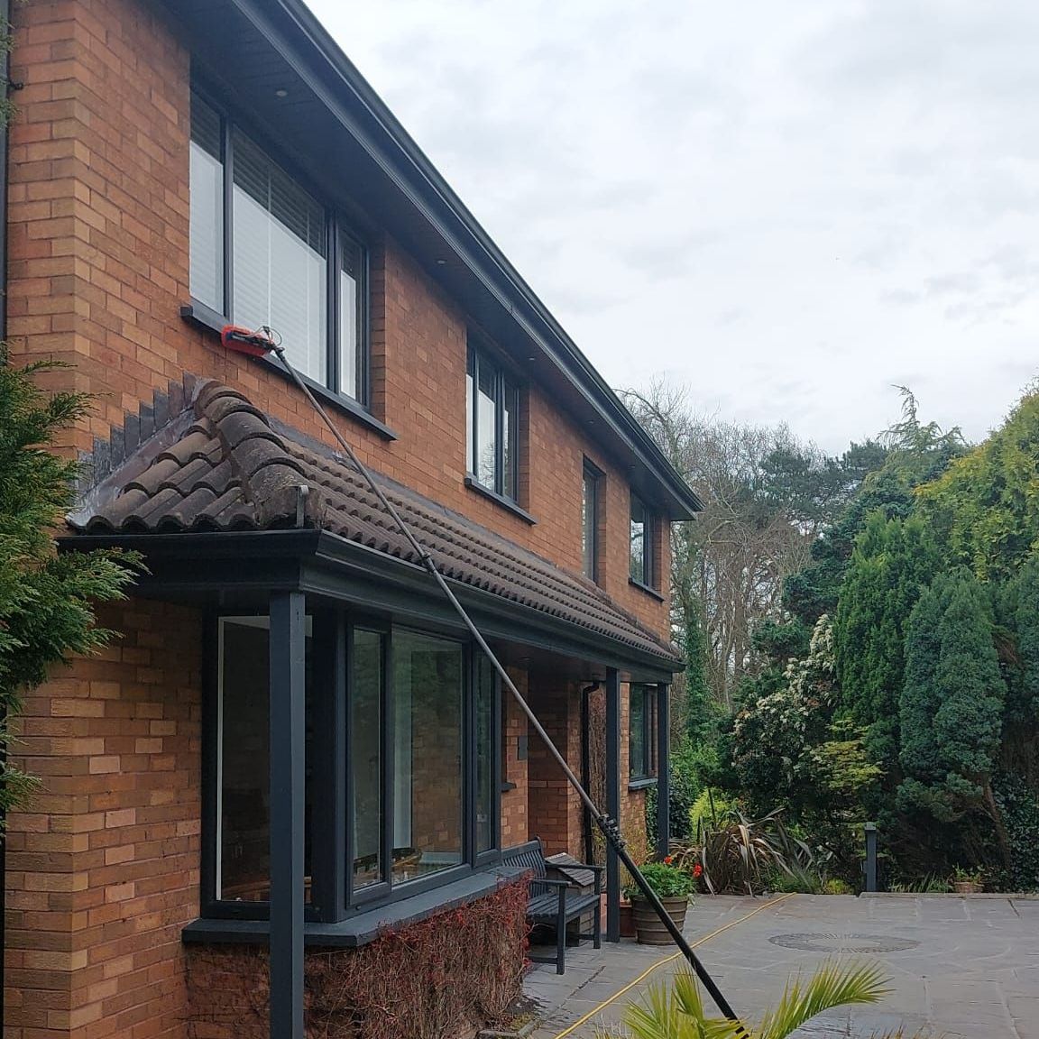 A large brick house with a hose attached to the side of it.